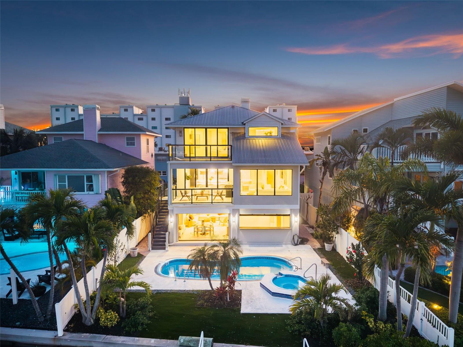 A statement of coastal elegance and architectural refinement, 8505 Blind Pass Dr. stands as a breathtaking waterfront masterpiece—crafted for the discerning buyer seeking unparalleled luxury, flawless design, and an effortlessly elevated lifestyle. Completely reimagined with no expense spared, this 3-bedroom, 3-bath, 2,600 sq. ft. residence blends bespoke finishes with sophisticated coastal living just moments from the Gulf’s white-sand shores. Upon entry, you’re greeted by an atmosphere of curated luxury: wide-plank wood-look tile floors sweep through the home, enriched by custom shiplap detail, designer lighting installations, and a cohesive palette reminiscent of an ultra-high-end seaside resort. Every space has been intentionally designed for beauty, comfort, and livability. At the heart of the home lies the showstopping gourmet kitchen, where panoramic water views frame an extraordinary culinary environment. A professional-grade 48" gas range, handcrafted Zellige tile, sculpted quartz surfaces, and a dramatic waterfall island elevate both everyday living and grand-scale entertaining. The expansive scullery—thoughtfully conceived as a true back kitchen—provides exceptional storage, prep space, and luxury utility. A glass-front, temperature-controlled wine room displays your collection as an art form. The entire top floor is dedicated to indulgence. The primary suite offers a sanctuary of serenity with hypnotic water views, a private balcony ideal for sunbathing or sunset gazing, and a sleek contemporary fireplace. The spa-inspired ensuite is a masterpiece of design, featuring floating vanities, exquisite artisanal tilework, a sculptural soaking tub, and a fully customized boutique-style dressing room complete with washer/dryer connection—bringing penthouse-level luxury to the waterfront. An adjoining flex room provides versatility for a private office, recreation lounge, or exclusive primary-suite sitting room, all while overlooking the shimmering Blind Pass waterway. The lower level elevates coastal living with exceptional functionality: a two-car garage, storage for boating, beach, and pool essentials, and a sophisticated pool-house room with dual full-height glass garage doors that open directly to the pool terrace. This creates a seamless indoor-outdoor enclave ideal for lavish entertaining and waterfront relaxation. For boating enthusiasts, the private dock and deep-water access provide the ultimate luxury—immediate entry to the Gulf and intracoastal waterways from your own backyard. Enjoy sunrise reflections over the water, golden coastal sunsets from the front of the home, and effortless walkability to the beach. A residence of this caliber is exceedingly rare—offering turnkey perfection, world-class amenities, and the pinnacle of Florida waterfront luxury. This is more than a home. It is a coastal masterpiece destined to impress.