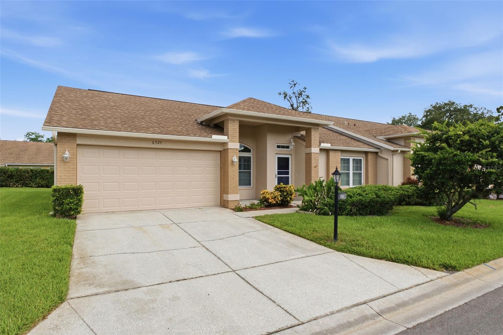 If you've been searching for a home that allows you to spend less time maintaining and more time enjoying life, this may be exactly what you've been waiting for. Located in Timber Greens, one of Pasco County's premier gated 55+ golf communities, this move-in-ready villa offers the perfect blend of comfort, convenience, and active adult living.
One of the first things you'll notice is how spacious the home feels. Vaulted ceilings, abundant natural light, and an open layout create an inviting atmosphere that lives much larger than its square footage would suggest. The generous living and dining areas flow seamlessly into the kitchen, family room, and screened lanai, creating a floorplan that feels both open and comfortable for everyday living.
The updated kitchen features granite countertops, abundant cabinet and counter space, a breakfast bar, and a bright dining area surrounded by plantation shutters. Its central location creates an easy flow throughout the home, making it ideal for everything from quiet mornings to gathering with friends and family.
The primary suite offers a walk-in closet and private bath with dual sinks, while the spacious guest bedroom provides comfortable accommodations for visiting family and friends. An additional storage room off the kitchen offers valuable space for hobbies, organization, seasonal items, or extra household storage—a feature not often found in many villas.
One of the highlights of the home is the oversized screened lanai, providing the perfect place to enjoy your morning coffee, unwind with a good book, or relax after a day on the golf course. It serves as a true extension of the living space and adds to the home's comfortable, easy-living feel.
Beyond the home itself, Timber Greens offers an exceptional lifestyle centered around recreation, social connection, and convenience. Residents enjoy an 18-hole par-71 golf course, clubhouse, pro shop, heated pool and spa, tennis courts, pickleball courts, bocce, shuffleboard, arts and crafts activities, social clubs, and the popular 19th Hole Bar & Grill.
This is more than just a villa—it's an opportunity to simplify your life without sacrificing the space, comfort, and lifestyle you've worked hard to enjoy.