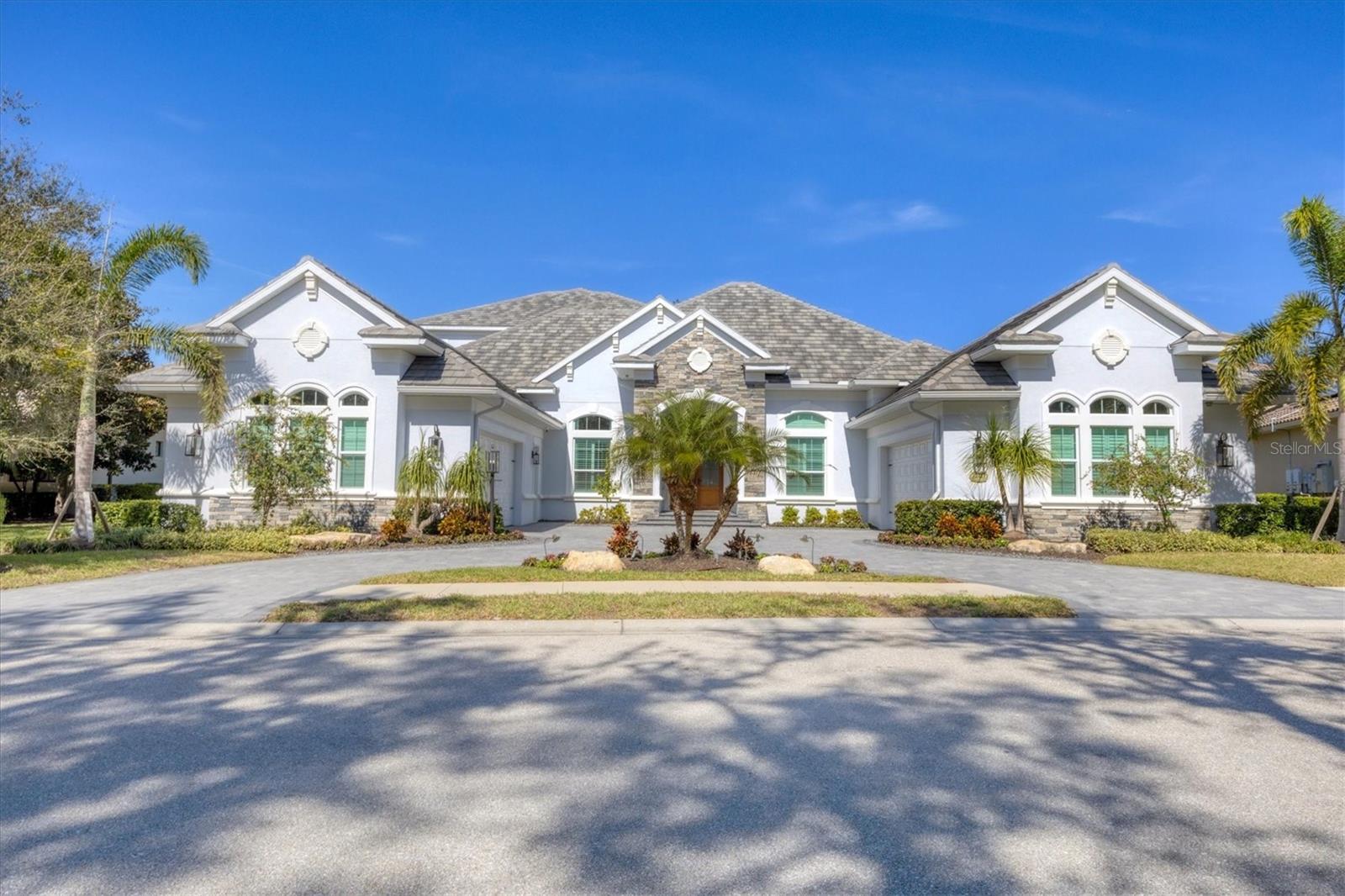 Welcome to 12411 Highfield Circle, a breathtaking custom-built estate in the gated community of Lakewood Ranch Country Club. Spanning nearly 6,100 square feet under air and 9,234 total square feet of covered space, this Neal Signature Homes masterpiece, built in 2021, combines cutting-edge technology, impeccable craftsmanship, and luxurious amenities. Designed for both elegance and functionality, this home boasts impact glass, high-end appliances, and a four-car air-conditioned garage with a circular driveway. At the heart of the home, the chef’s kitchen is a culinary dream, featuring top-of-the-line Wolf and Sub-Zero appliances, including double Wolf ovens, a Wolf steam oven, convection microwave, a six-burner dual fuel range, a warming drawer, and a 42” Pro Wall Chimney Hood. A full Sub-Zero refrigerator and freezer, two dishwashers, an ice maker, a wine refrigerator, and a beverage center ensure every convenience is at your fingertips. A reverse osmosis filtration system with an instant hot water dispenser and whole-house water filtration elevate the kitchen’s functionality.Designed for modern luxury, this home is equipped with three tankless water heaters, three HVAC systems, and a Mitsubishi mini-split air conditioning system in both garages. A whole-home Control4 audio system, including speakers throughout the lanai and landscaping, brings seamless smart home automation. The Hide-a-Hose central vacuum system adds another layer of convenience. Entertainment is redefined with a state-of-the-art home theater featuring a 160” screen, a Sony 4K professional laser projector, and a 7.6.2 Bowers & Wilkins Atmos sound system. Cinematech acoustics, design, and luxury seating provide a true cinematic experience. The living room is a welcoming space with a gas fireplace and French doors leading to the resort-style outdoor retreat. Step outside to your 38' x 20' heated saltwater pool and spa, surrounded by travertine marble decking. The expansive summer kitchen with seating for up to 12 and is a grilling enthusiast’s paradise, featuring a Lynx 30” Asado griddle, Napoli pizza oven, Primo ceramic charcoal Kamado grill, Marvel outdoor refrigerator, beer cooler with dual taps, and a Trade Winds 60” vent hood with a 1,200 CFM blower. The outdoor bar offers seating for six, while the panoramic screen-enclosed pool area features a turfed cornhole court.This exceptional home offers six bedrooms, five full bathrooms, a private office with golf course views, and a spacious home gym. The thoughtfully designed layout includes four bedrooms on the first floor and two additional bedrooms upstairs. The underground drainage system ensures efficient water management.Offering an unmatched blend of luxury, technology, and functionality, this extraordinary estate is a rare opportunity in Lakewood Ranch Country Club. Schedule your private showing today and experience the pinnacle of Florida living