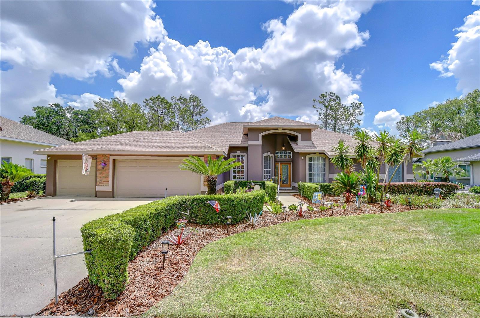 Welcome to this beautifully updated Sunrise-built bungalow perfectly positioned along the 2nd green in the highly sought-after gated community of River Hills Golf & Country Club. Offering 4 bedrooms, 3 full bathrooms, private office, and a 3-car garage, this spacious one-story home blends elegant living spaces with incredible indoor-outdoor entertaining. From the moment you step through the front door, you’re welcomed by formal living and dining spaces that create a warm and inviting first impression. Just off the entry, a private office with French doors and a closet offers exceptional flexibility as a home office, den, playroom, or potential guest space. The heart of the home features an open-concept kitchen and family room designed for gathering and everyday living, all overlooking the resort-style outdoor retreat and picturesque golf course views. The family room is highlighted by iconic tall cathedral windows that flood the home with natural light, creating a bright and airy atmosphere, while a charming wood-burning fireplace adds warmth, character, and the perfect focal point for cozy evenings at home. The secluded primary suite is privately tucked away on one side of the home and offers direct lanai access, dual walk-in closets, and a beautifully updated en-suite bath complete with separate vanities, a soaking tub, walk-in shower, and custom tile work throughout. Three additional spacious bedrooms are situated along a separate hallway, creating privacy for family or guests, and share two full bathrooms, including a convenient pool bath with direct lanai access. Step outside to what truly sets this home apart — an incredible outdoor living experience designed for year-round Florida enjoyment. The upgraded PebbleTec saltwater pool is surrounded by a travertine pool deck and expansive covered lanai featuring an outdoor kitchen, updated lighting, ceiling fans, upgraded lanai screening with fiberglass screening along the lower half for added durability and comfort, and a customizable color-changing lighting system that creates the perfect ambiance for entertaining or relaxing evenings outdoors, all perfectly positioned to capture stunning views of the 2nd greenway. Additional updates include upgraded hurricane-rated garage doors, a newer roof, fresh interior and exterior paint, upgraded landscaping, newer carpeting in the bedrooms and office, maple wood cabinetry, granite countertops and backsplash, variable-speed pool pump, newer water heater, and a 16 SEER A/C system for improved efficiency and comfort. Located within the guard-gated River Hills Golf & Country Club community, residents enjoy tree-lined streets, scenic golf course surroundings, and convenient access to top-rated schools, shopping, dining, parks, and everything the Tampa Bay area has to offer. This meticulously maintained home offers the perfect combination of luxury, comfort, and lifestyle.