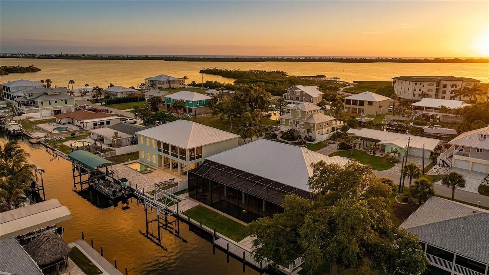 BOATER’S PARADISE — Welcome to a ONE-OF-A-KIND CUSTOM WATERFRONT ESTATE perfectly positioned on a DEEP WATER CANAL with NO BRIDGES and QUICK ACCESS to the GULF, LEMON BAY, STUMP PASS, BEACHES, AND MORE!

Completed in 2021, this ELEVATED CUSTOM HOME was thoughtfully designed for both LUXURY LIVING and PEACE OF MIND, featuring BLOCK CONSTRUCTION, IMPACT WINDOWS & SLIDERS, a METAL ROOF, composite trim, and quality craftsmanship throughout. Offering over 7,500 SQUARE FEET, this property combines spacious living with exceptional durability and efficiency and features a FULL HOME ELEVATOR for your convenience. SUPER LOW TRANSFERABLE FLOOD INSURANCE POLICY.

Inside, you’ll immediately notice the soaring COFFERED CEILINGS, crown molding, waterproof luxury vinyl plank flooring, and expansive OPEN FLOOR PLAN built for effortless indoor/outdoor living. IMPACT POCKET SLIDERS open seamlessly to a MASSIVE WATERFRONT BALCONY overlooking the HEATED SALTWATER POOL & SPA — the perfect place for a morning coffee or sunset cocktails with breathtaking sunrise views.

The CHEF’S KITCHEN features modern granite counter-tops, CUSTOM SHAKER CABINETRY with dovetail drawers, STAINLESS STEEL APPLIANCES including DOUBLE OVENS and a WINE FRIDGE, a custom WALK-IN PANTRY, over-sized island, and abundant prep space.

The spacious PRIMARY SUITE offers stunning WATER VIEWS, tray ceilings, private balcony access through French doors, DUAL CALIFORNIA-STYLE WALK-IN CLOSETS, and a spa-inspired en-suite bath with a WALK-AROUND SHOWER, DOUBLE VANITIES, and SOAKING TUB.

A secondary EN-SUITE BEDROOM also features balcony access and convenient private access near both the ELEVATOR and stairs — ideal for guests. The third bedroom offers generous flexibility as a large guest suite, office, or flex space.

Downstairs, enjoy an OVERSIZED 4-CAR GARAGE with room for a 5TH VEHICLE, EPOXY FLOORS, additional storage rooms, a FULL BATH, and a HUGE BONUS ROOM with direct access to the pool area through two sets of sliders.

Your private outdoor oasis includes a HEATED SALTWATER POOL & SPA with PEBBLETEC FINISH, TANNING SHELF, BUBBLERS, COLOR-CHANGING LIGHTS, automatic fill system, multi-level spa jets, and premium paver decking. The OUTDOOR KITCHEN features granite counters, MARINE-GRADE CABINETRY, beverage refrigerator, and stainless disposal — perfect for entertaining waterfront guests.

The FULLY FENCED backyard also includes TWO PRIVATE DOCKS with electric and water service, 100 FEET OF CONCRETE SEAWALL, plus a COVERED 10,000-LB BOAT LIFT, making this a true SAILBOAT WATER retreat built for serious boaters.

Additional upgrades include a WHOLE-HOUSE WATER FILTRATION SYSTEM, SOLID CORE DOORS, FULLY INSULATED INTERIOR WALLS, built-in GENERATOR SWITCH, circular driveway, and MORE.

Located in Englewood’s highly sought-after coastal boating community near marinas, beaches, sandbars, golf, world-class fishing, waterfront dining, and the charm of “OLD FLORIDA” living. NO HOA and NO DEED RESTRICTIONS.

Be sure to request the FEATURE SHEET and view the WALK-THROUGH VIDEO. 3D VIRTUAL TOUR is attached to Zillow Listing.

This is not a home you will want to miss. Book your showing today!