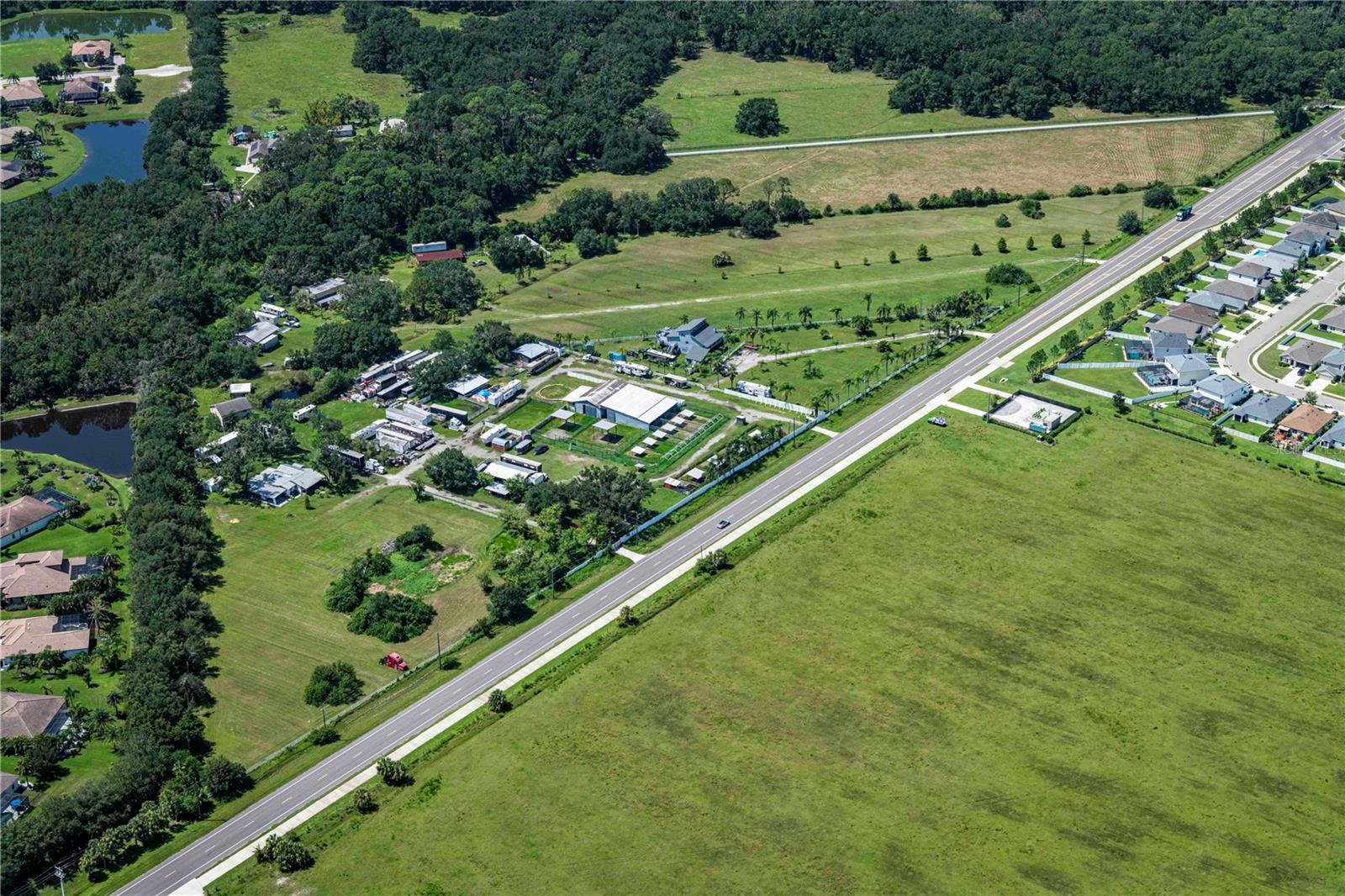 Rare 9.93-acre contiguous assemblage comprised of two parcels (211 & 307 Rye Rd NE) in Northeast Manatee County's high-growth Rye Road/Waterline Road corridor. Property is high and dry in Flood Zone X - no flood insurance required. Current AG zoning offers flexibility for a variety of uses, including private estate/compound, equestrian property, professional/medical campus, or future residential development (potential UF-3 reclassification under Envision Manatee 2026 goals). Existing improvements include 4,000+ total SF of residential space with a 2025-renovated primary residence featuring new impact-rated windows, a 2022 roof, and covered front and back porches. Additional structures include a 1,920 SF barn and 8,500 SF canopy - ideal for equipment storage, horses, or staging. Property is eligible for the Greenbelt tax exemption, keeping carry costs low. Perfectly positioned to serve the growing residential demand from Lakewood Ranch and Parrish. Assemblages of this size are increasingly scarce in this corridor. Bring your vision - or your builder.