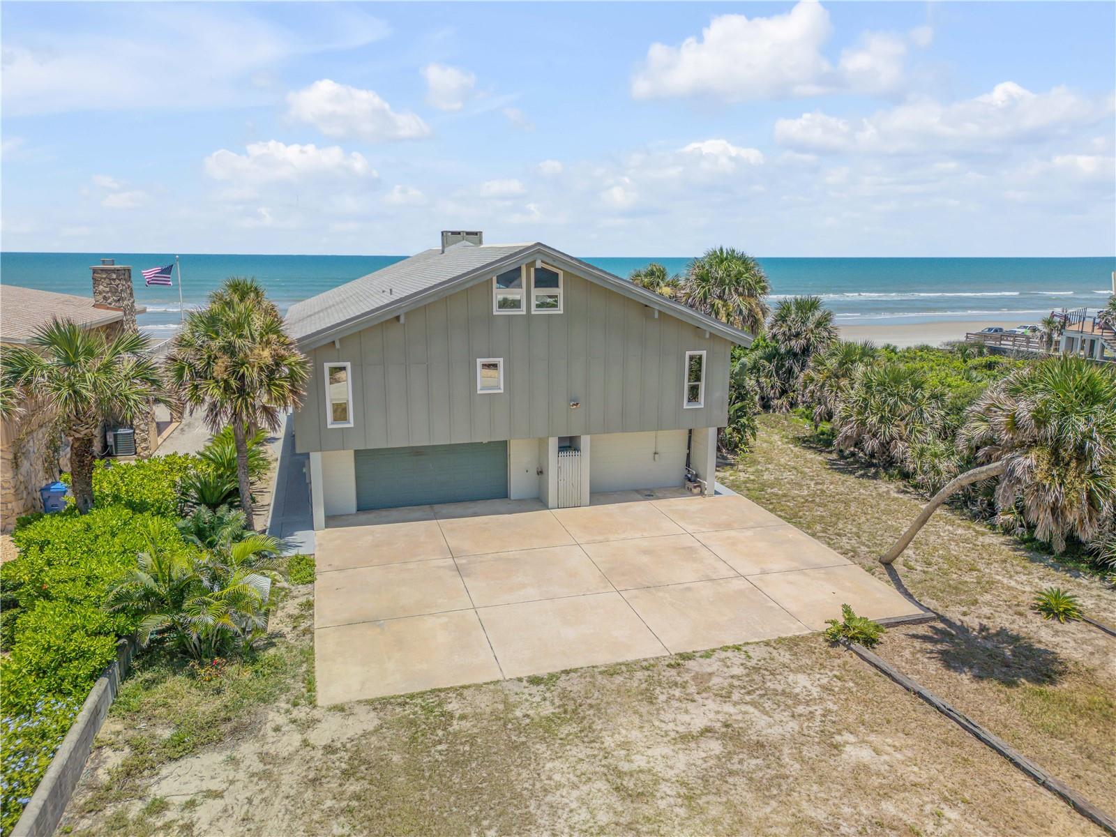 Direct oceanfront estate home on the coveted no-drive oceanfront section of New Smyrna Beach! Experience the ultimate beachfront lifestyle with this expansive 5-bedroom, 3-bathroom residence boasting 4,600 sq. ft. of living space, including a bonus room and open-air loft. Located on Van Kleeck Dr, one of the most desirable streets in New Smyrna Beach with multi-million dollar oceanfront homes, with direct access to the serene no-drive beach. The open floor plan features an incredibly spacious living room with an open fireplace, perfect for entertaining. Large windows offer stunning direct ocean views and open to a large wrap-around deck. The deck, with concrete restoration completed in 2019, is ideal for enjoying morning coffee or evening drinks with family and friends, soaking in the panoramic ocean views. The well-laid-out kitchen includes stainless steel appliances, a large dining island, and ample cabinetry, making entertaining a breeze.  Five spacious bedrooms provide plenty of room for family and guests. The open-air loft and bonus room offer additional versatile space or a great area for the children to play.  An extra bar/kitchenette was added downstairs in 2023, enhancing the home's functionality and entertainment options. Most windows are equipped with hurricane shutters for added peace of mind.  Enjoy the convenience of nearby restaurants, shopping, and entertainment, while relishing the tranquility of beachfront living. Make this dream home yours today!