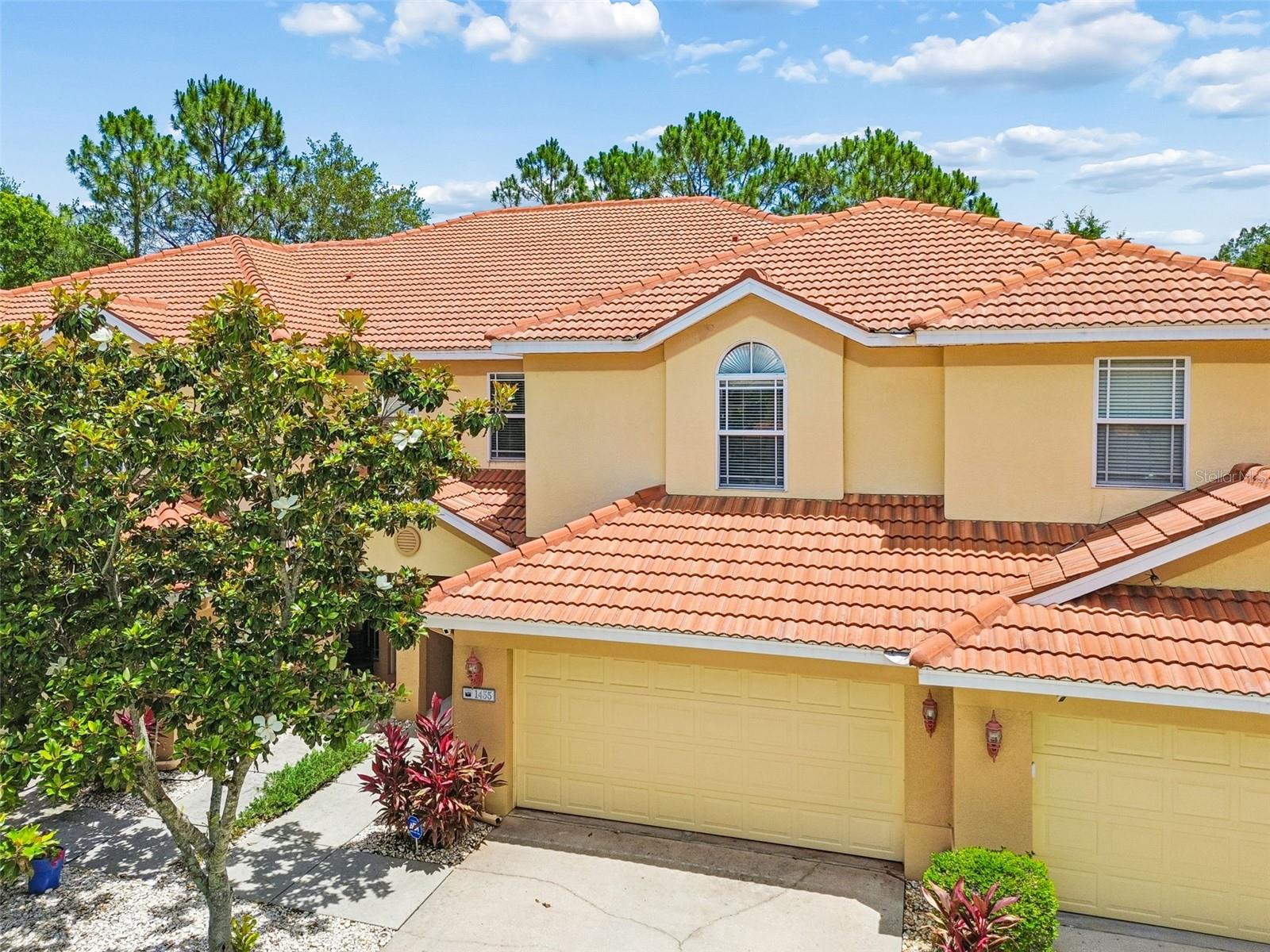 Virtually Staged. Discover exceptional space and comfort in this beautiful, move-in-ready, 1,881-square-foot townhome, on a quiet cul-de-sac in a desirable neighborhood in Tarpon Springs. Designed for easy living, this spacious three-bedroom home offers a freshly painted, functional layout filled with a welcoming feeling throughout. Boasting a barrel tile roof, the home provides the ideal blend of comfort, cooled by a 2022 air conditioner, and low-maintenance living. A modest $350 monthly fee covers the roof, exterior, landscaping, sprinklers, cable TV, high-speed internet, plus ADT security system and monitoring. The property includes a private two-car garage, driveway, mailbox and entry. Inside, the spacious kitchen showcases granite countertops, wood cabinetry and 2023 LG appliances. A breakfast bar connects to the great room where the living and dining areas feature high ceilings and wood floors, with a convenient powder room beneath the stairs. Tall sliding glass doors open to a screened porch overlooking a pond, ideal for relaxation. Upstairs has luxury vinyl flooring and high ceilings. The primary suite features a tray ceiling, walk-in closet, and large ensuite bath with dual sinks, soaking tub and a walk-in shower. A versatile bonus room separates the two guest bedrooms and a full bath from the primary suite and laundry room. Conveniently near Pinellas Trail, Sunset Beach, Innisbrook Golf Resort, along with the dining and shopping of Tarpon Springs, Palm Harbor and Dunedin, this home offers the ideal mix of style, safety and convenience. Schedule your private showing today.