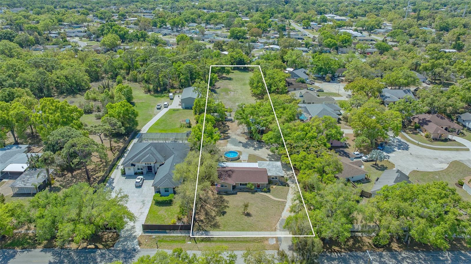 Old Florida awaits you…this updated ranch home is situated on 1.45 acres with an in-town location. Property will be steps away to a new County Park in final approval / develpment. Bring the whole family and all the animals to enjoy this charming home and guest cottage. RE-1 zoning allows for horses, goats and chickens as family pets. The 3-bedroom 2 bath primary home has been entirely updated and is very well maintained. The open great room plan is a winner for family gatherings. The kitchen features newer SS appliances, granite and solid wood cabinetry. The bedrooms are  split plan with maximum separation from the primary suite. The primary bedroom is enormous with a large walk-in closet with built ins. French doors lead out to the large screened in porch that overlooks the pool and grounds. When you go through the electric gate is when the magic happens. The above ground pool and fire pit are just a couple of the features of the property; The parking area has room for all of your toys (e.g. RV Parking). There is a small shed with carport for all of your gardening tools. The 1 bedroom 1 bath detached guest cottage has a full kitchen and full size inside laundry.  A private patio under a giant shade tree adds to the charm. Beyond all of that is a fenced pasture that could be home to the animals, garden and more. Plenty of room to add more out buildings if desired. Close proximity to all that an international shopping mall and dining has to deliver. Nathan Benderson Park, Mote Marine and more are at your fingertips. Don’t miss this opportunity to have a country lifestyle in a intown location.