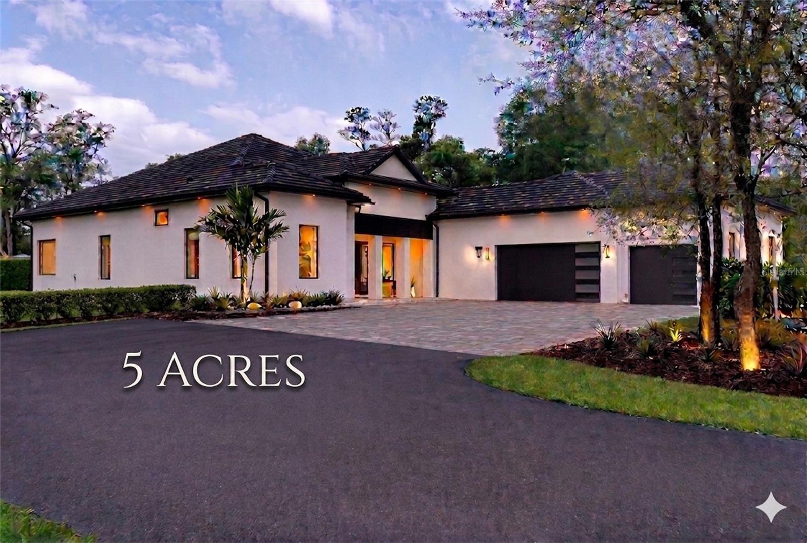 Custom-Built 2024 Private 5-Acre Estate. High & Dry in Gated Happy Trails. Welcome to a rare opportunity to own this exceptional estate situated on 5 pristine high-and-dry acres, one of the highest elevations within the community. Positioned on a desirable corner lot with dual gated entrances, the property offers enhanced accessibility, privacy, and flexibility for a variety of uses. Ideally located just minutes from Celebration, Reunion, and Walt Disney World, this exceptional property offers the perfect balance of luxury, privacy, and convenience with no HOA. A long, elegant private driveway leads to this impressive residence featuring 4 bedrooms, 3.5 bathrooms, an oversized 3-car garage with EV charging outlet, and a thoughtfully designed open-concept modern floor plan with expansive living spaces throughout. Step inside to experience soaring 14-foot ceilings throughout the entire home, enhanced by tray ceilings in the dining room, living room, and primary suite, along with a striking 16-foot cathedral ceiling in the designer kitchen, creating a bright and dramatic architectural presence. The gourmet kitchen is a true centerpiece, showcasing an oversized island with Italian granite, extensive custom cabinetry, a hidden oversized walk-in pantry, and a seamless connection to the main living and dining areas, ideal for both everyday living and entertaining. The elegant dining room features a stunning double glass-door wine display, while a beautifully designed wet bar with wine cooler adds both style and functionality. The spacious living area is anchored by a modern built-in electric fireplace with custom finishes. The breakfast area is framed by oversized picture windows, offering beautiful views of mature oak trees and the natural landscape, creating a serene, park-like setting. The luxurious primary suite offers a spa-inspired bathroom featuring a freestanding soaking tub positioned beneath a large picture window, a walk-in glass shower, and refined finishes that create a true retreat experience. All additional bedrooms are generously sized and designed for comfort and privacy. Outdoor living is equally impressive, featuring a covered lanai with a fully equipped outdoor kitchen, extensive paved areas, and expansive open acreage surrounded by beautiful mature trees. Zoned for horses, the property offers ample room for a barn, workshop, RV storage, or future additions. Additional features include double-glazed energy-efficient windows, premium modern motorized blinds throughout the entire home, large sliding glass doors, a private water well eliminating monthly water costs, and a seven-zone irrigation system.