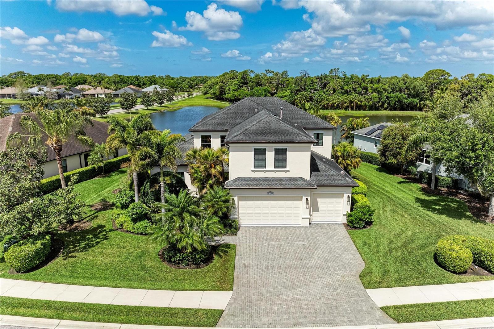 ****NEW ROOF, NEW AC just replaced & IMPACT WINDOWS AND DOORS**** Positioned within the gates of GreyHawk Landing, this former Homes by Towne Sawgrass model showcases refined two-story living with distinctive architectural detail and thoughtfully designed spaces throughout. Originally built to highlight the builder’s craftsmanship, the residence features extensive trim work, custom built-ins, and a spacious floor plan tailored for both everyday comfort and effortless entertaining. For added peace of mind, a NEW ROOF was recently replaced (10 year manufacturers warranty & 5 year workmanship warranty - transferrable). The main living areas are finished in elegant tile flooring, while the bedrooms feature engineered hardwood, creating a clean, cohesive interior with NO CARPET. At the heart of the home, the gourmet kitchen is appointed with upgraded appliances, including a THERMADOR COOKTOP and BOSCH DISHWASHER, along with abundant workspace and a layout that flows seamlessly into the surrounding gathering areas, ideal for both casual living and hosting guests. Upstairs, a generous loft and separate recreation room provide flexible space for a media lounge with ceiling speakers, game room with POOL TABLE, or additional living area. Outdoor living embraces Florida’s indoor-outdoor lifestyle. A spacious screened lanai overlooks a tranquil pond, while the TEXTURED MARBLE TILE DECK frames the private pool and spa, offering ample space for relaxing and entertaining. CUSTOM LANAI LIGHTING enhances the setting as the day transitions into evening. A convenient pool bath, positioned separate from the main living areas, provides easy access for outdoor use. Landscape lighting highlights the lush surroundings and adds to the home’s evening ambiance. Additional features include a NEW HVAC systems (2026 & 2024), three-car garage with EV charger, whole-house surge protector,  central vacuum system, laundry room featuring an LG WASHER AND DRYER with utility sink, and custom closets in the primary suite. Residents of GreyHawk Landing enjoy a gated, master-planned setting spanning nearly 1,000 acres, with over half the community preserved as natural open space featuring ponds, wetlands, and mature wooded areas. Community amenities include two clubhouses, a lagoon-style pool with water features, a separate lap pool, fitness center, tennis, pickleball and basketball courts, sports fields, fishing dock, and miles of scenic walking and biking trails. Conveniently located just east of I-75 in Bradenton, residents have easy access to Lakewood Ranch, downtown Sarasota, top-rated schools, shopping, and dining. The Gulf Coast beaches, including Anna Maria Island, are just a short drive away, offering an exceptional balance of natural beauty, community living, and coastal convenience. Theme parks are also within reach for an easy day trip.