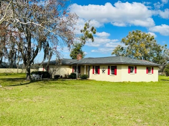 Bring your animals and enjoy the country lifestyle on this beautiful 5-acre mini farm in Gilchrist County! This fully fenced and cross-fenced property is set up for livestock and features a 20x55 metal barn with 12x35 side wings, horse or livestock stalls, wash station, sink, and electric service. A large 40x60 concrete block workshop offers two oversized bays with ample space for tractors, RVs, boats, equipment, or even a semi-truck. The spacious 4-bedroom, 3-bath farmhouse offers 1,992 square feet of living space and includes a large 14x32 covered back porch overlooking the property. Inside, the bright galley kitchen opens to comfortable living areas designed for both everyday living and entertaining. The living room features a beautiful brick wood-burning fireplace with a sitting hearth as its centerpiece. Additional flexible living spaces include a family room/dining area and a multipurpose room ideal for an office, hobby space, or playroom. The converted garage serves as a generous primary suite complete with a large bedroom, private bath, and oversized closets. Conveniently located just minutes from town, yet offering the peace and privacy of country living, this property has no HOA and no subdivision restrictions. Enjoy easy access to the Suwannee River and several nearby springs for swimming, boating, and outdoor recreation. Country living is calling!