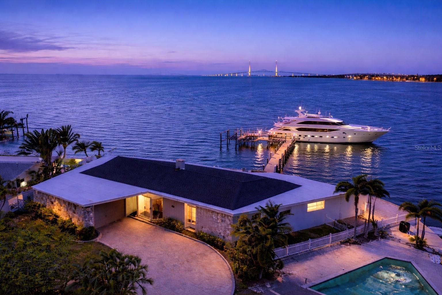 Perfectly positioned to capture the best of both worlds, this exceptional waterfront estate offers a rare blend of serene coastal living and effortless access to vibrant city life. Ideally located just minutes from downtown, award-winning Gulf beaches, premier shopping, and an array of top-tier restaurants, this residence delivers the ultimate Florida lifestyle.
Set on deep, protected water with direct Gulf access, this property is a dream for boating enthusiasts—yet equally appealing for those who value convenience, culture, and connection. Spend your mornings on the water, afternoons exploring boutique shops or waterfront cafés, and evenings enjoying the energy of downtown just moments away.
Designed with both elegance and resilience in mind, the home has remained high and dry through past hurricanes, offering exceptional peace of mind in a premier waterfront setting.
A true boater’s sanctuary, the private dock features a double lift accommodating vessels up to 26’ and 38’, along with an impressive low-tide depth of approximately 6 feet—ideal for larger boats. With quick, easy access to open Gulf waters, every day invites a new adventure.
Inside, the home offers a seamless single-story layout with breathtaking water views from nearly every room, creating the feeling of living directly on the water. The gourmet kitchen is a chef’s dream, appointed with top-of-the-line Viking appliances and a cooktop perfectly positioned to overlook the tranquil waterfront.
Outdoor living is equally captivating, featuring a 170-foot seawall lined with elegant, cool-to-the-touch brick pavers, a sparkling pool, and expansive areas designed for both relaxation and entertaining. Enjoy fishing from your dock, watching dolphins and manatees glide by, or simply taking in the serene beauty of your surroundings.
This beautifully appointed residence offers 4 bedrooms and 3.5 bathrooms, complemented by a spacious 2-car garage, a Tesla charging station, a cozy fireplace, and a private dog run—thoughtfully designed to blend comfort, convenience, and modern luxury.
With approximately 180 feet of open water frontage, the property showcases breathtaking panoramic views, including a direct sightline to the iconic Sunshine Skyway Bridge. What makes this home truly extraordinary is the rare combination of deep-water boating capability and its unbeatable proximity to downtown, world-class beaches, shopping, and exceptional dining—creating a lifestyle that is as effortless as it is luxurious.