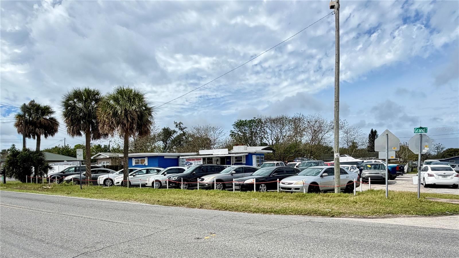 Prime commercial opportunity available for owner-user or investor with no lease restrictions. Zoned C-2, this versatile property supports a wide range of uses including office, retail, and automotive sales. Situated on a high-visibility corner lot along Grand Blvd with an estimated traffic count of approximately 18,000–22,000 vehicles per day, the property benefits from strong exposure and is just 0.16 miles from State Road 54. The offering includes two parcels totaling 0.38 acres (156' x 103') with a 1,600 sq ft building currently configured for office and dealership operations. Currently operating as an independent car dealership, the property benefits from a grandfathered use, making it especially valuable as automotive zoning approvals and licensing have become increasingly difficult to obtain. This is an ideal opportunity for owner-users seeking visibility, automotive businesses, or investors looking for a flexible commercial asset in a growing New Port Richey corridor.