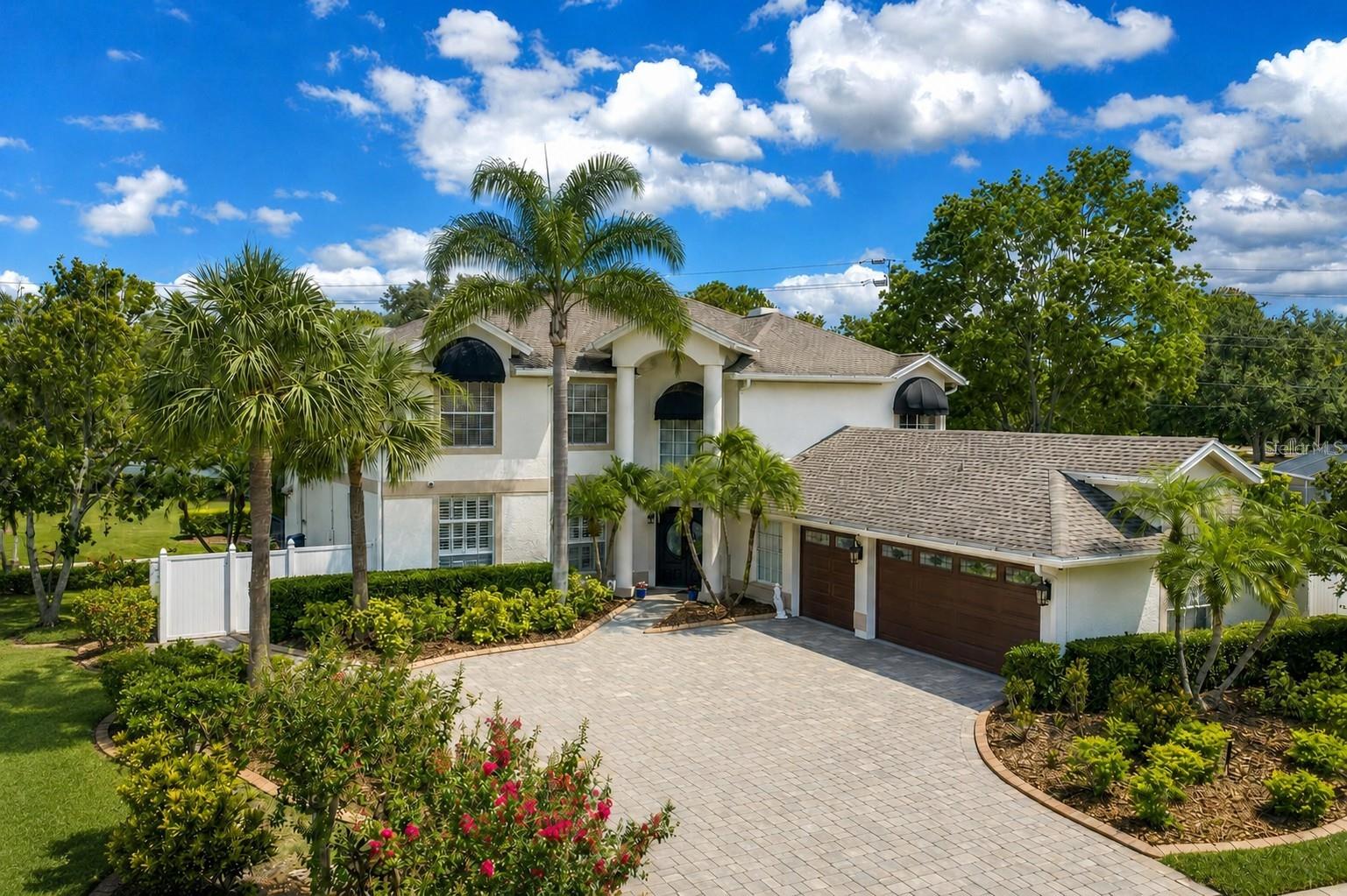 Set on an oversized lot in the Countryway area, this home offers spacious living areas and an outdoor retreat made for everyday enjoyment. A vaulted foyer, custom wrought-iron staircase, and soft-lit stairs create a memorable first impression. Throughout the main level, hardwood and tile flooring, lofty ceilings, crown molding, plantation shutters, custom architectural details, and accent lighting give the home a welcoming ambiance. The main floor offers room to gather, entertain, and spread out. The formal dining room sits between the kitchen and media room, creating a natural flow for dinner parties, holidays, or quiet evenings at home. French doors open to the media room, while pocket doors connect to the kitchen, giving each space openness and definition. At the heart of the home, the kitchen is made for more than cooking. With double ovens, an induction cooktop, stainless steel appliances, custom cabinetry, granite countertops, two pantries, handmade accent tile details, a dinette area, and a coffee/wine bar, it is a space where mornings can begin slowly and evenings can unfold easily. Sliding doors lead directly to the lanai, pool, and outdoor kitchen, making it simple to move from coffee at the counter to dinner outside. The great room brings everyone together with a gas fireplace, built-in cabinetry, and another seamless connection to the outdoor living area. Whether it is a quiet night by the fire, a weekend gathering, or a day spent moving between the pool and kitchen, this space feels relaxed and inviting.

A main-level room currently used as an office adds valuable flexibility. Near the main living areas, it can serve as a fifth bedroom, guest space, home office, hobby room, or whatever life calls for next. An elegant powder room with Venetian plaster walls adds another thoughtful design moment on the main floor. Upstairs, the home becomes a private retreat. The spacious primary suite is bright and calming, with hardwood flooring, a sitting area, and French doors that open to a private balcony overlooking the golf course. Here, the day can begin with quiet views and end with fresh air just outside your bedroom. The primary bath includes a walk-in shower, soaking tub, dual sinks, a vanity area, and a large, customized walk-in closet. Three additional upstairs bedrooms each offer vaulted ceilings, hardwood flooring, and ample closet space. Outside, the covered lanai is where this home truly shines. Designed as an extension of the living space, it offers room to relax, dine, entertain, and enjoy Florida living year-round. The custom outdoor kitchen is fully equipped with an infrared grill, ventilation hood, burners, refrigerator, ice maker, sink, generous counter space, and bar seating. Whether hosting friends by the pool, preparing dinner outside, or enjoying a quiet evening under cover, this lanai is built to be used and enjoyed. An outdoor shower adds convenience after time in the pool or yard. Behind the scenes, practical upgrades support comfort and peace of mind, including two A/C units, three water heaters, a Water-Right whole-house filtration and conditioning system with a carbon filtration component, and a security system with 16 exterior cameras recording around the clock. With its generous lot, dramatic architectural details, flexible living spaces, private upstairs retreat, and exceptional outdoor entertaining area, this home offers a lifestyle centered around comfort, connection, and enjoying every part of home.