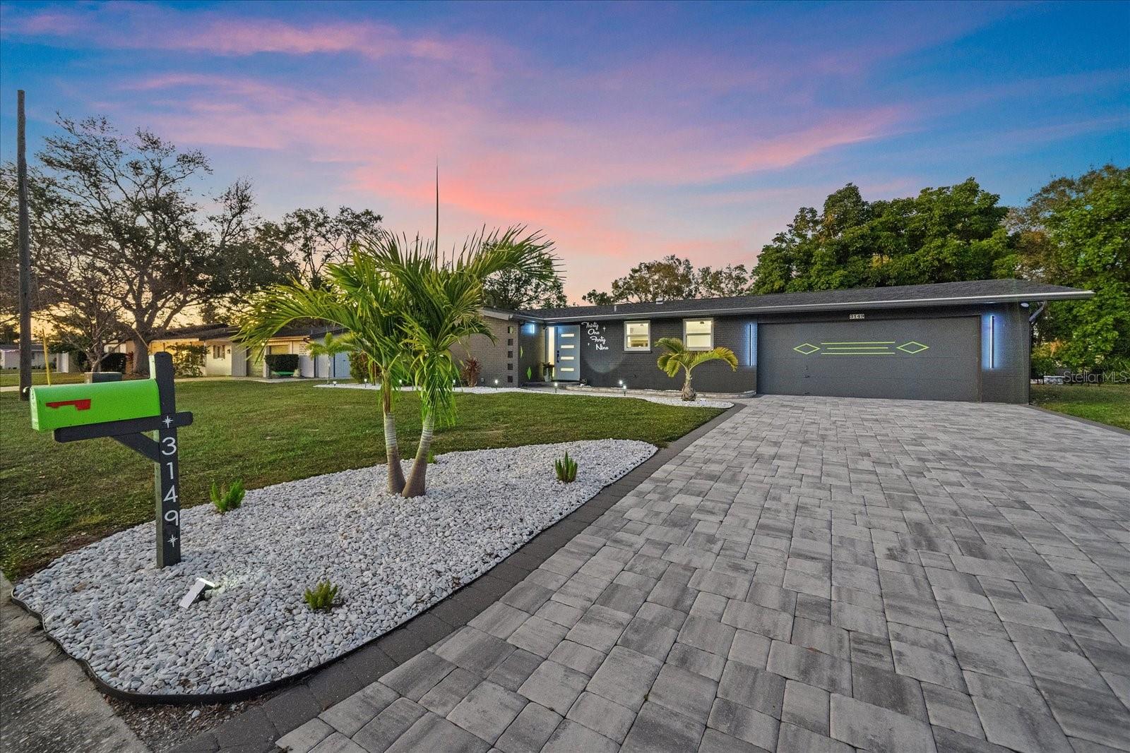 Mid-century inspired architecture paired with a complete modern renovation, set along a tranquil creek that offers a peaceful waterfront backdrop with a unique elevated setting. Positioned high above the water, the home enjoys serene views, with frequent wildlife sightings from both inside and out.

Recent improvements include a new roof, hurricane-rated windows, designer lighting, and all new large-format tile flooring throughout. A dramatic step-down living area adds architectural character, while the custom kitchen remodel features high-end KitchenAid appliances and bar seating ideal for entertaining.

Two spacious bedrooms include walk-in closets, and the expansive Florida room—finished with upgraded window tint—serves as a versatile flex space that could easily accommodate a Murphy bed. The home offers two beautifully updated bathrooms, including a hall bath with a separate tub and walk-in shower, and a well-appointed primary bath with a large walk in shower and bench.

Situated on a 10,000+ sq ft oversized corner lot, the property features a new paver driveway, extended patio, and a generous side yard that could accommodate a future pool or expanded outdoor living space. Mature trees create a natural backdrop behind the home, enhancing the peaceful water setting. Despite its waterfront location, the home sits high above sea level, has never flooded, and has withstood hurricanes.

The garage is enhanced with a newly installed Shark Floor coating, providing a durable, sleek, and easy-to-maintain finish. Enjoy tranquil outdoor living with water behind the home, where you’ll regularly spot fish, turtles, and a variety of birds in your own private nature retreat.
Not located in a flood zone, and with no HOA or CDD fees, this move-in-ready property offers freedom, flexibility, and peace of mind.

Located in the highly desired Southgate Neighborhood. Conveniently located minutes to downtown Sarasota, approximately 10 minutes to Siesta Key Beach, and between two top-rated hospitals. Turn-key, move-in ready, and truly one of a kind.