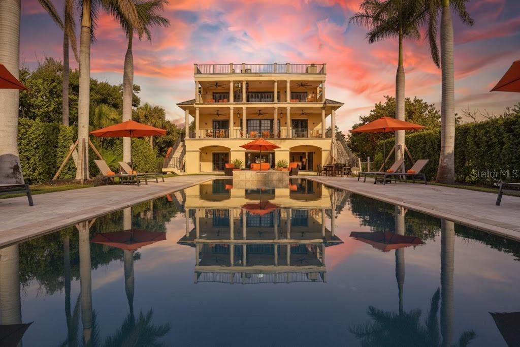 Welcome to 'Avoca'—a captivating GULF FRONTAGE/PRIVATE BEACH estate, ideally positioned along the coveted Tween Waters stretch of Captiva Drive on Captiva Island. Offering rare privacy, expansive grounds, and DIRECT beach frontage, this remarkable property showcases panoramic views of the Gulf of Mexico and a private beach path to sugar-sand shores. Avoca is one of the rare properties in Captiva that showcases the luxurious resort-style pool in the back of the home, allowing for STUNNING SUNSET VIEWS AND IMMENSE OUTDOOR SPACE! Spanning over one acre and set at one of the highest elevations on the island (X Zone Flood Elevation), Avoca is located within the Estate Zoning district—allowing for up to three structures, providing exceptional flexibility for expansion or additional guest accommodations. The lush tropical setting frames a true resort-style backyard, featuring a 20' x 60' pool with integrated spa, a full outdoor kitchen, and one of the most impressive outdoor entertaining environments on Captiva. Recent upgrades include a newer roof and impact-rated windows and doors for added peace of mind. Inside, the residence is thoughtfully designed for relaxed luxury and effortless entertaining. Four expansive levels of decking invite breathtaking sunsets and Gulf breezes from nearly every room. The main living level offers a generous open layout with a spacious chef’s kitchen, open dining area, fireplace, elevator, multiple guest bedrooms, and light-filled gathering spaces. The third-floor owner’s suite is a private sanctuary, complete with a balcony, sitting area, office nook, and a well-appointed en-suite bath. Additional guest suites and a loft area provide comfortable accommodations for family and friends. Crowning the home is one of the largest rooftop sundecks on the island, delivering elevated, unobstructed coastal views. Whether envisioned as an extraordinary private Gulf-front retreat, a luxurious vacation escape, or a high-performing rental investment, Avoca represents a rare and compelling opportunity on world-renowned Captiva Island.