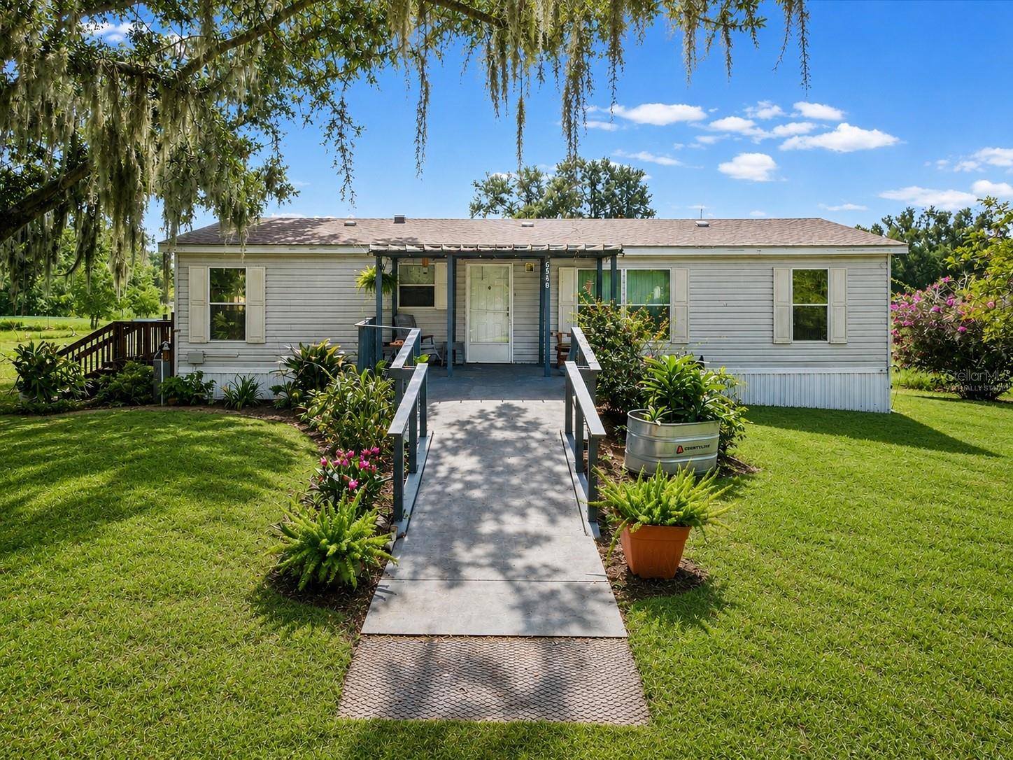 Virtually Staged. Rare opportunities like this are becoming increasingly difficult to find in Land O' Lakes. Nestled beneath a breathtaking canopy of majestic grandfather oaks draped in Spanish moss, this 2007 manufactured home sits on 2.77 acres of AR-zoned land in one of Pasco County's growing corridors.

The home features 3 bedrooms, 2 bathrooms, and approximately 1,296 square feet of living space. Serviced by private well and septic, the property offers the independence and flexibility that many buyers are searching for. A detached storage building and expansive outdoor space provide endless possibilities for hobbies, storage, and recreation.

Whether you're looking for room for your RV, boat, trailers, or simply a peaceful place to spread out and enjoy Florida living, this property delivers. The AR zoning provides flexibility that is becoming increasingly difficult to find in Land O' Lakes.

Conveniently located near shopping, dining, schools, and major commuter routes, you'll enjoy the perfect balance of privacy and accessibility. Land O' Lakes High School is less than a mile away, and the surrounding area continues to experience steady growth, making larger parcels increasingly scarce.

If you've been searching for acreage, privacy, and the charm of Old Florida living, this property is worth a closer look. Opportunities to own nearly three acres in Land O' Lakes don't come along often.

Schedule your private showing today and discover everything 6548 Lake Irene Drive has to provide.