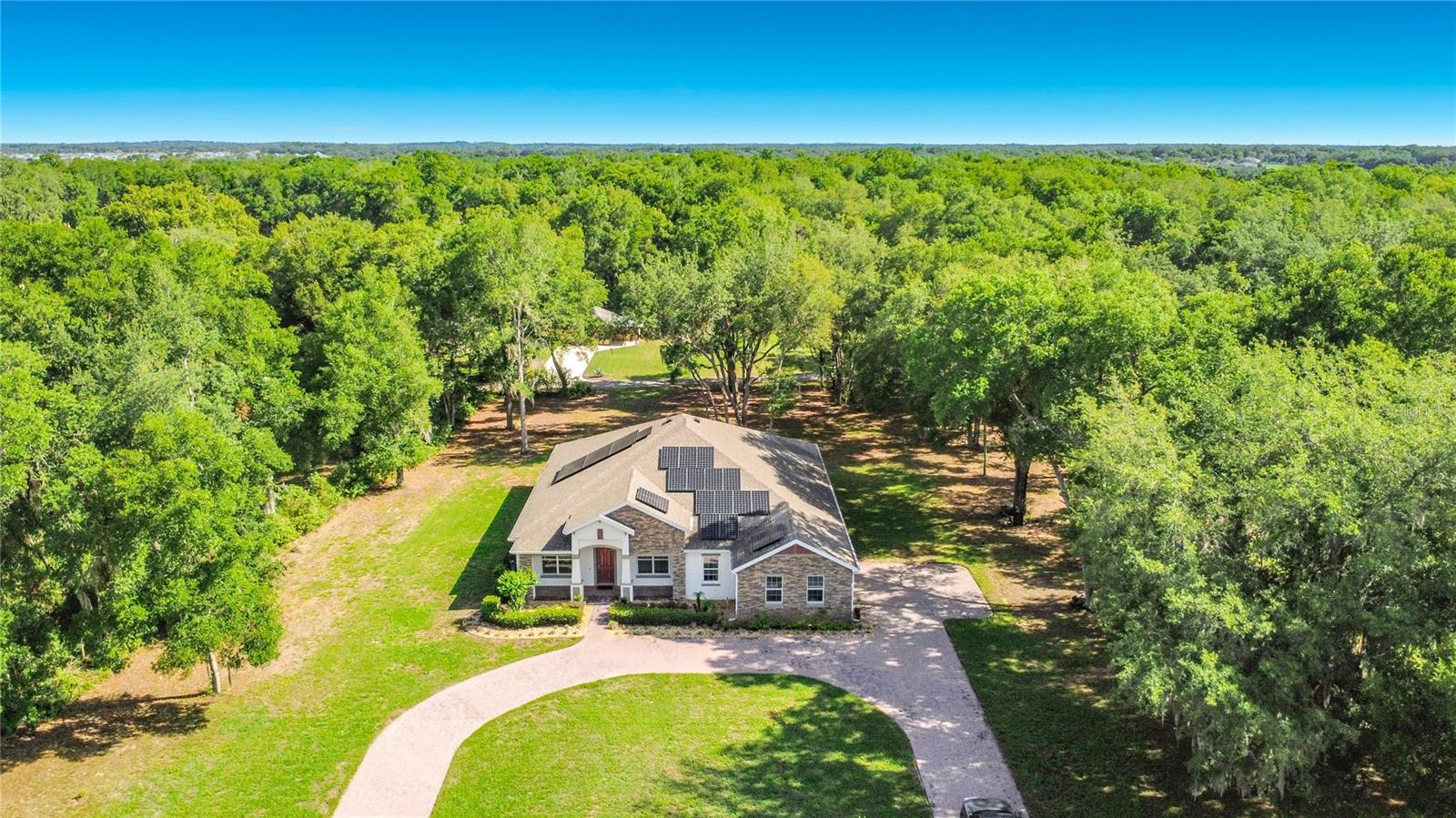 Welcome to your private oasis in the highly desirable Wingspread community. If you are tired of cramped, cookie-cutter subdivisions where your neighbors are just feet away, this spectacular 2023-built Luxury Home is the breath of fresh air you have been searching for. Situated on a massive, sprawling one-acre lot with a large circular driveway, an oversized 3-car garage, and no direct rear neighbors, this property provides the rare gift of true space, privacy, and peace. The exterior is a masterclass in curb appeal, featuring extensive professional landscaping, brilliant landscape lighting, and custom built-in LED strip lighting under the perimeter soffits that makes the home shine at night. Combining a quiet, country feel with incredibly low HOA fees, this property delivers upscale living without the restrictive, crowded feel of traditional Florida communities.
Step through the commanding 8-foot front door into an interior designed to impress, where luxury and functionality meet. The home completely eliminates carpet, boasting seamless wood-plank tile flooring, tall tray ceilings, elegant crown molding, and 8-foot interior doors throughout. The thoughtfully designed layout greets you with a dedicated home office on the left—complete with custom LED lighting—and a sophisticated formal dining room on the right. The expansive main living room serves as the heart of the home, beautifully illuminated by pendant lights, trendy fandeliers, and dimmable LED fans. From here, double doors lead out to a massive screened-in back porch and patio with double screen doors, providing the perfect venue to look out over your huge, private backyard and enjoy the tranquil Florida evenings in complete serenity.
The gourmet kitchen is a chef’s dream, fully equipped with sparkling granite countertops, premium stainless steel appliances, double ovens, and crisp white shaker-style cabinets that offer abundant storage. Everyday chores become a breeze in the oversized laundry room, which includes a utility sink, matching white shaker cabinets, extra closet space, and the included washer and dryer. Designed with a split-bedroom floor plan, the home ensures ultimate privacy for everyone. The generous spare bedrooms feature walk-in closets with custom organizing systems, complemented by multiple linen closets throughout the halls. The guest bathrooms are beautifully appointed with granite countertops, adult-height vanities, custom tiled surrounds, and add-on bidets on all toilets, with one bath featuring a tub with acrylic sliding doors and another offering a glass-framed tiled shower.

The primary suite is a true sanctuary of relaxation, offering tray ceilings and tons of space. The attached en-suite bath mimics a luxury spa, featuring a deep garden tub, a double-sink vanity with a dedicated makeup area, a massive closet with custom shelving, and a spectacular "super shower" outfitted with a rainfall showerhead and multiple body jets. Beyond its beauty, the home is packed with high-end, forward-thinking upgrades, including a premium Trane HVAC system equipped with an infrared/UV air filter. Best of all, you can say goodbye to high electric bills with a fully paid-off Tesla Solar system, complete with a Powerwall backup battery and a dedicated electric car charger in the garage. With all kitchen and laundry appliances included, this immaculate, energy-independent estate is completely turnkey and ready to give you the spacious, private lifestyle you deserve.