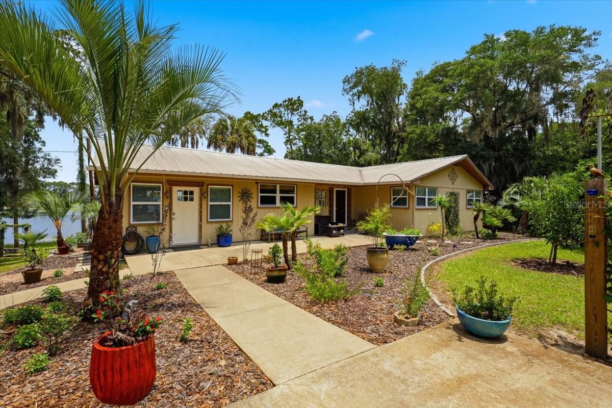 Rare waterfront retreat with 150 feet on a private spring-fed lake, offering exceptional privacy and breathtaking views. This 3-bedroom, 2-bath mid-century home blends timeless charm with modern updates, including quartz countertops, glass mosaic backsplash, custom tile accents, premium appliances, a walk-in pantry, and a beautifully remodeled guest bath. The spacious Florida room showcases panoramic lake views.
Enjoy outdoor living with a 90-foot dock featuring a large entertainment platform, louvered pergola, power, water, boat ramp, and kayak storage. A separate tiny guest cabin with covered porch and private yard provides flexible space for guests, an office, or studio.
The property also includes a detached 4-car garage, powered 3-stall pole barn, full RV hookup m, sandy beach swimming area, fire pits, and a circular driveway. Mature edible landscaping features a wide variety of fruit and nut trees, creating a one-of-a-kind lakefront estate designed for recreation, relaxation, and country living.