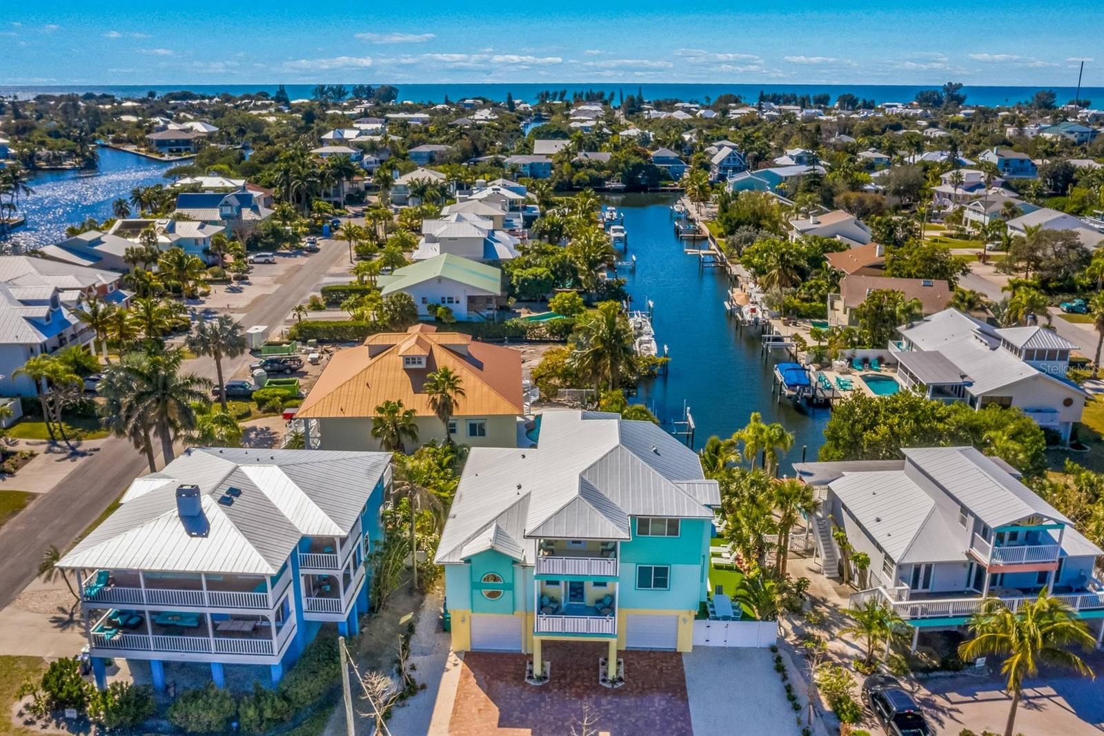 Let the island breeze guide you home to 505 S Bay Boulevard, a waterfront haven where the world slows down and coastal living feels like poetry. Tucked along the tranquil north end of Anna Maria Island, this elevated five-bedroom, five-bath home invites you to experience a lifestyle wrapped in beauty, comfort, and pure island magic. Step inside and discover more than 3,200 square feet of thoughtfully designed living space, filled with natural light and framed by sweeping water views. The open-concept floor plan flows seamlessly, anchored by a gourmet kitchen featuring dual islands, high-end finishes, and a gas cooktop—perfect for everyday living and effortless entertaining. Multiple ensuite bedrooms, a versatile top-floor loft, and separate living areas provide privacy and flexibility for family, guests, or long-term stays. Four balconies extend the indoor spaces outdoors, offering uninterrupted views of sunrises over the bay and serene evenings on the water. This gorgeous home also presents a strong investment opportunity, with the potential to generate six-figure annual vacation rental income. Custom features abound, including a heated saltwater pool, a boat dock and lift on the canal, an eco-friendly rainwater cistern system, two tankless water heaters, an R38 metal roof with spray-foam insulated walls for energy efficiency, and a 25-year termite warranty for added protection. For boating enthusiasts, the home’s 32 feet of saltwater-canal frontage, deeded boat slip, and lift provide direct access to the Intracoastal Waterway and Gulf of Mexico. Durable coastal construction, impact-resistant features, and low-maintenance materials ensure peace of mind while embracing the waterfront lifestyle. Beyond the home, Anna Maria Island offers one of Florida’s most celebrated coastal experiences. A short stroll or bike ride takes you to Pine Avenue’s boutiques, cafés, and galleries, while world-renowned beaches with soft white sand and clear blue water await for sunbathing, shelling, or paddleboarding. From casual beach days to boating excursions and sunset views over the Gulf, this address delivers a truly effortless island lifestyle. At 505 S Bay Boulevard, you’re not just investing in a home—you’re securing a front-row seat to the island life that makes Anna Maria Island one of Florida’s top coastal destinations. Here, every day feels like a retreat, and every moment is framed by the natural beauty and charm of one of the Gulf Coast’s most desirable communities.
