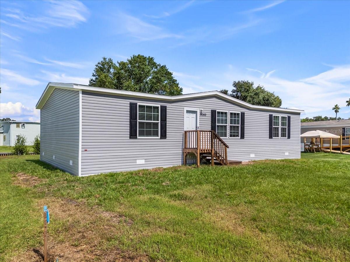Experience the perfect blend of modern living and natural beauty with this brand-new manufactured home Frostproof FL, offering 1 acre lot, this beautifully designed 3-bedroom, 2-bathroom home offers a spacious, open floor plan ideal for modern living. From the moment you step inside, you’ll appreciate the high-quality finishes and attention to detail with vinyl flooring throughout. The spacious living room seamlessly flows into the kitchen and dining area, perfect for entertaining guests. The master bedroom is a serene retreat, with a luxurious en suite master bath with a dual sink vanity, shower and a walk-in closet. The chef-inspired kitchen is equipped with brand-new stainless-steel appliances, featuring a central island with a breakfast bar, shaker-style cabinets and pantry. Two additional bedrooms provide plenty of space for family members or guests, each with walk-in closet. Enjoy the added convenience of a utility room, perfect for laundry and extra storage. The guest bathroom offers a tub, perfect for unwinding after a long day. Nestled in the heart of Central Florida's beautiful Lake Wales Ridge, Frostproof, known as "The Friendly City," offers a relaxed, Old Florida charm and a wonderful community feel. It’s an ideal setting for anyone seeking tranquility without sacrificing convenience. Enjoy an abundance of outdoor recreation with access to multiple renowned fishing and boating lakes, including Lake Clinch and Lake Reedy, famous for trophy bass fishing. Nearby Arbuckle Wildlife Management Area and Tiger Creek Preserve offer scenic trails for hiking and birdwatching. This prime Central Florida location is less than an hour's drive to major attractions, including LEGOLAND, and just over an hour to Disney World and the greater Orlando area. Quick access to US-27 and Scenic Highway 17. Schedule your private showing today!