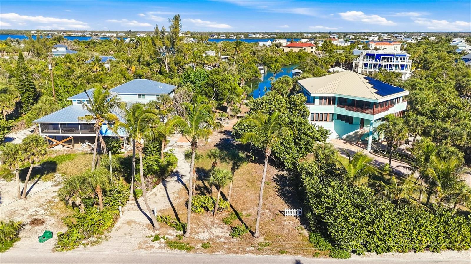 This truly rare property does not become available often for purchase.  What makes these parcels so special is that it is two platted lots/building sites, each lot approximately 80 feet by 120 feet which equates to about 19,200 square feet (approximately ½ acre).  It is located across the street from the beach and has beach access directly across from the property with partial Gulf views.  For boating purposes, there is a dock, approximately 60 feet of concrete seawall, as well as a private ramp.  The property is located on a waterway known as the T Canal offering (great boating water), a view straight down the canal with easy boating access to the Intracoastal Waterway and the Gulf of Mexico with no bridges.  In effect, this property offers great boating location and canal views as well as the Gulf of Mexico across the street.  These parcels have been mostly cleared and have mature coconut palm trees.  There is a water meter on site as well as electricity.  The owner of this property can have his boat in the T Canal right behind the home and the sands of the Gulf of Mexico just steps away.