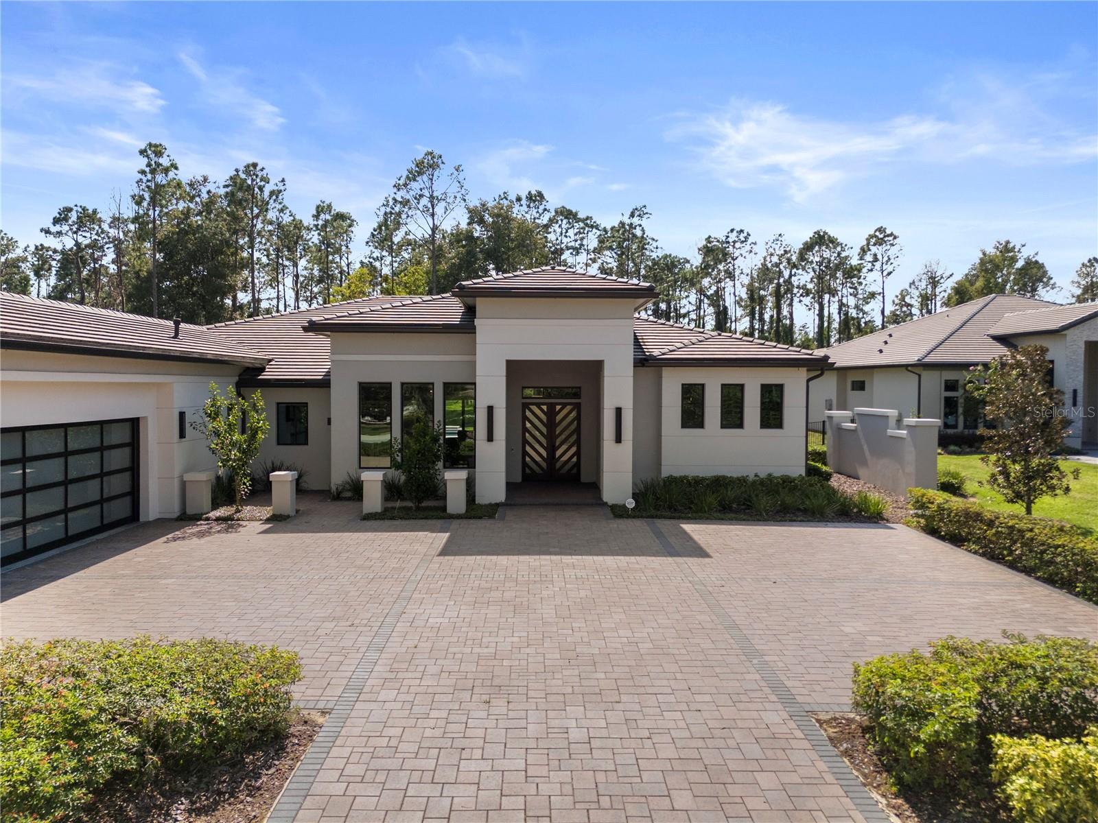 Experience the Pinnacle of Luxury Living in Bella Collina. Welcome to a one-of-a-kind luxury estate nestled on an oversized, meticulously landscaped lot in the beautiful, guard-gated community of Bella Collina—Central Florida’s premier golf and lifestyle destination.This stunning 4-bedroom, 5-bath modern masterpiece with an extra room offers the perfect blend of sophistication, comfort, and innovation. From the moment you arrive, you’ll be captivated by the breathtaking curb appeal, highlighted by a paver-stone driveway and a 3-car garage with mini-split A/C for added convenience.Inside, designer features abound—porcelain floors throughout except the primary suite where there is elegant engineered hardwood floors, motorized shades, and full smart home technology for lighting, climate, audio, video and security.The expansive great room is the heart of the home, designed for both everyday living and elegant entertaining. It boasts a large screen TV, a sleek electric fireplace, and soaring ceilings that create a sense of warmth and grandeur.The chef’s kitchen is a culinary dream, equipped with a Thermador refrigerator/freezer, Wolf 6-burner gas range, and Wolf double oven, a Wolf microwave oven, and custom cabinetry with premium finishes.Step outside to the resort-style lanai, thoughtfully divided into three distinct areas:A relaxation zone with a gas fireplace and another large screen TV.A versatile dining or gathering area adaptable to your needsA summer kitchen with grill, sink, refrigerator, and bar seatingThe over 1500 square foot covered lanai is enclosed with retractable screens that open to reveal the stunning pool with spa.  The outside cool deck surrounding the pool has multiple seating areas.  The pool even has an extra area that is shallow for lounge chairs to relax while in the water.For the golfer there is a challenging artificial turf custom putting area is provided for honing those short game skills.You will be amazed and the expansive fenced in back yard landscaped and lighted for your pleasure.Retreat to the luxurious primary suite where with the touch of a button the shades retract to reveal your beautiful pool area and back yard, or lower for your secluded hideaway.   The primary suite features its own large-screen TV, dual walk-in closets and finishes that feel straight out of a high-end resort including built in mini fridge, sink and a spa inspired bathroom with soaker tub, an oversized walk-in shower with built-in benches and multiple shower heads.On the other side of the house is a room that’s use will be only limited by your imagination.  It could be a second primary, an office, a media room, an exercise room, or game room, or whatever you decide.  Designed with corner sliding doors that fully retract, offering immediate access to and views of the stunning lanai, pool, and back yard.Additional features of this amazing home include:A private in-law suite with exterior entrance, kitchenette, walk-in closet, full bath, and covered porch.A dedicated office with custom built-insSpacious guest bedroom and elegantly appointed ensuite bathrooms throughout the house.Living in Bella Collina means enjoying world-class amenities including 24-hour gated security, a Nick Faldo–designed championship golf course, luxury spa, tennis, fitness center, and a picturesque Tuscan-style clubhouse.This is more than just a home—it’s a lifestyle.This home has far too many exquisite features to list.  This home must be viewed in person.