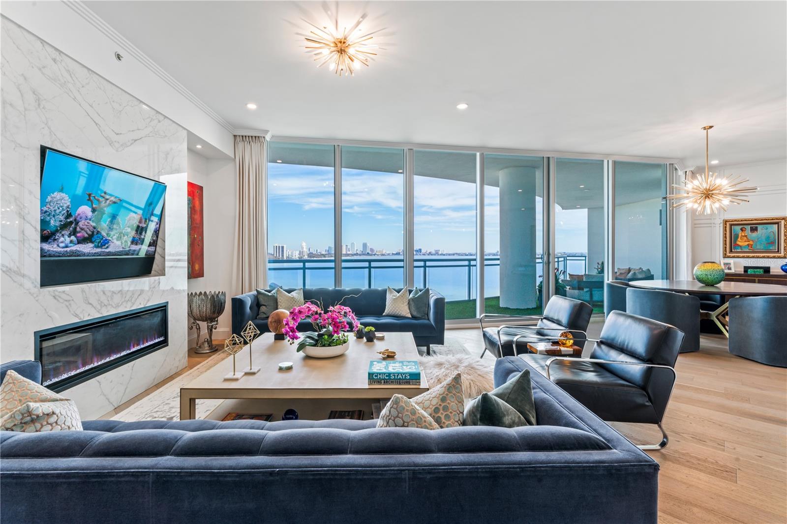 MUST SEE this dreamy stunningly designed condo inspired by the Baccarat Hotel in NYC. The views are absolutely breathtaking with expansive water views framing a picture-perfect postcard view of Downtown Tampa, by far the best view on Bayshore. If you love the daytime views, the nighttime views are even better!  Every detail of this home has been painstakingly designed and customized to create a true luxury oasis in the sky.  Step off the elevator directly into your private foyer with beautiful black and white geometric tile and notice the uniquely designed millwork with "scorched" wood walls, and a gold leaf ceiling. The home features hardwood flooring throughout, gorgeous custom cabinetry, double thick quartz kitchen island, Wolf Induction Cooktop (wired for gas if you want a gas range), Subzero Refrigerator and all finished off with a beautiful custom marble backsplash. Upgrades are nearly endless in this home and include: built-in electric fireplace with book matched porcelain "marble" slabs, Sonos system with Ghost speakers in the foyer, living, and dining rooms, turf covered oversized balcony, custom electronic voice controlled drapes and lighting, venetian plaster bathroom, wall treatments +++ The Virage is a luxury high-rise featuring 24/7 concierge, pool overlooking Bayshore, spa, grilling area, fire-pit, club room, meeting room, a large gym, massage room, private dog walk, dog spa, bike room, air conditioned storage, and 2 guest suites which can be reserved for your guests. Come live the lifestyle you deserve at the Virage Bayshore!