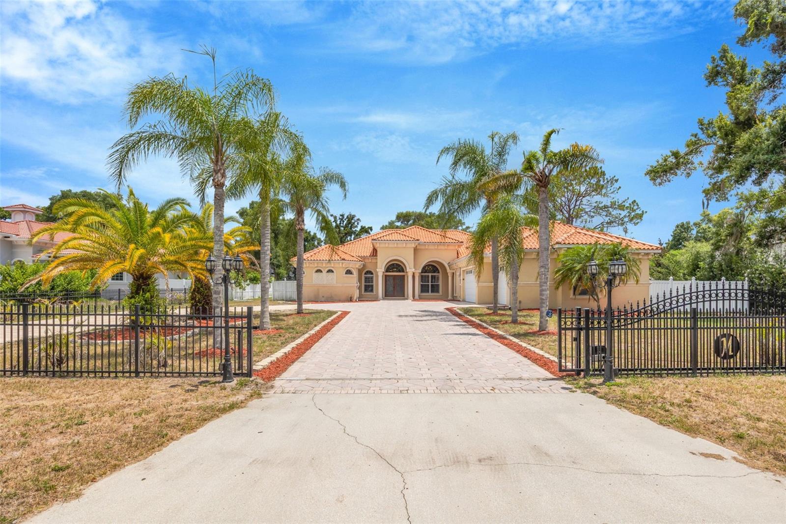 Exceptional Custom Built Home on a Private 0.76-Acre Homesite in Highly Sought-After Keystone! Located on a 0.76-acre lot with no HOA in Flood Zone X, this stunning one-story estate offers 5 bedrooms, a private office, bonus room, and an exceptional blend of luxury, comfort, and functionality. Designed with an open split-bedroom floor plan, the home features 12-foot ceilings, 8-foot doors, extensive crown molding, elegant tray ceilings, and beautiful travertine flooring throughout. The grand foyer welcomes you into formal living and dining rooms, while the spacious family room showcases a custom coffered ceiling, gas fireplace, and French doors leading to the outdoor living space. The gourmet kitchen is a chef's dream, featuring custom wood cabinetry, granite countertops, a large center island with prep sink, walk-in pantry, and premium Thermador appliances, including a gas cooktop with griddle, convection oven, refrigerator, and dishwasher, along with a Viking wine cellar. The luxurious primary suite offers Brazilian hardwood flooring, a spacious sitting area, custom walk-in closets, and private access to the pool. The spa-inspired primary bath features dual granite vanities, marble flooring, a Jacuzzi soaking tub, and an oversized walk-in shower with dual shower heads. The additional bedrooms are generously sized, while the dedicated office provides the perfect work-from-home space. The spacious bonus room offers endless possibilities and can serve as a second living area, media room, game room, or flex space to fit your lifestyle. A standout feature is the converted garage, thoughtfully transformed into private living quarters complete with a full kitchen and living room, making it ideal for multigenerational living, extended guests, or a private retreat. Enjoy Florida living year-round in the screened-in heated pool and spa featuring a paver pool deck, outdoor kitchen with JennAir grill, and stone gas fireplace—perfect for entertaining family and friends. The fully fenced backyard provides privacy and plenty of room to enjoy. Additional features include a tile roof, central vacuum system, electric shades, custom plantation shutters throughout, and quality craftsmanship throughout. Situated in the highly desirable Keystone of Odessa, this home offers estate-style living with the freedom of no HOA, while remaining close to top-rated schools, shopping, dining, and major commuter routes. Location, location, location! Easy access to all of Tampa Bay's most beautiful beaches, Tampa International Airport, Westshore Business District.