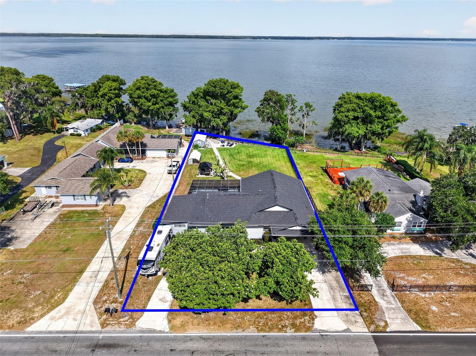Experience the ultimate Harris Chain lifestyle in this beautifully remodeled lakefront estate with NO HOA. Rest easy with a new roof (2022) and exterior paint.  Boasting over 100 feet of private shoreline on the 7,800-acre Lake Eustis, this 4-bedroom, 4-bathroom residence offers 3,388 square feet of modern amenities designed for both relaxation and grand entertaining. The heart of the home is a gourmet kitchen featuring sleek, soft-close cabinetry, granite countertops, and a high-end stainless appliance package, including a 5-burner gas range and dual ovens.  If that is not enough room the enormous family room has you ready to host everyone on the invite list.  The thought-out floor plan includes two ensuite bedrooms, providing perfect accommodations for guests or a multi-generational setup. Large picture windows throughout the family room, kitchen and dining room frame panoramic lake views and world-class sunsets. Step outside to your private oasis, featuring a sparkling swimming pool and a covered/enclosed boat dock equipped with two hoists. From your backyard, you can cruise to waterfront dining in Tavares, Eustis, or Mount Dora, or spend the day fishing the renowned Harris Chain. Located just minutes from shopping, restaurants, Waterman Hospital and entertainment, this home perfectly blends lakefront living with city convenience.