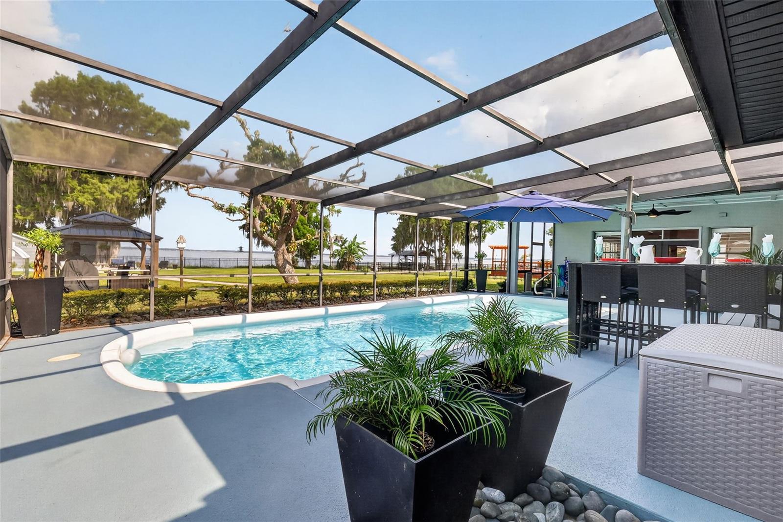 Experience the ultimate Harris Chain lifestyle in this beautifully remodeled lakefront estate with NO HOA. Rest easy with a new roof (2022) and exterior paint.  Boasting over 100 feet of private shoreline on the 7,800-acre Lake Eustis, this 4-bedroom, 4-bathroom residence offers 3,388 square feet of modern amenities designed for both relaxation and grand entertaining. The heart of the home is a gourmet kitchen featuring sleek, soft-close cabinetry, granite countertops, and a high-end stainless appliance package, including a 5-burner gas range and dual ovens.  If that is not enough room the enormous family room has you ready to host everyone on the invite list.  The thought-out floor plan includes two ensuite bedrooms, providing perfect accommodations for guests or a multi-generational setup. Large picture windows throughout the family room, kitchen and dining room frame panoramic lake views and world-class sunsets. Step outside to your private oasis, featuring a sparkling swimming pool and a covered/enclosed boat dock equipped with two hoists. From your backyard, you can cruise to waterfront dining in Tavares, Eustis, or Mount Dora, or spend the day fishing the renowned Harris Chain. Located just minutes from shopping, restaurants, Waterman Hospital and entertainment, this home perfectly blends lakefront living with city convenience.