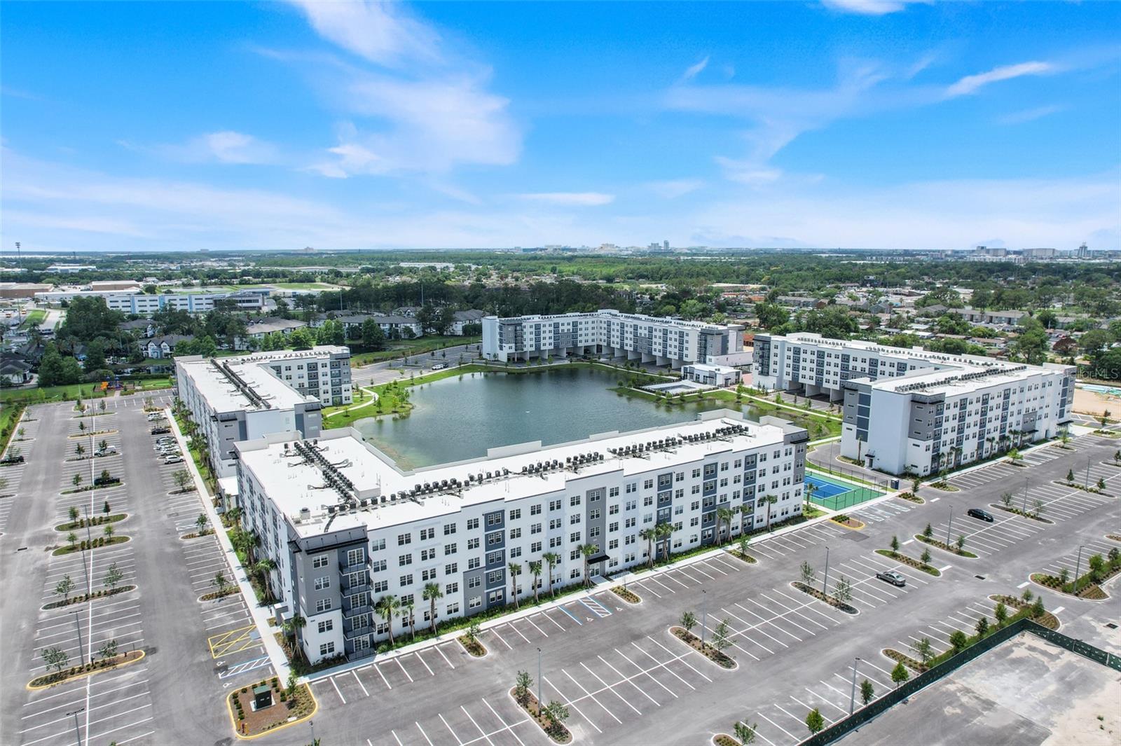 Welcome to Millenia Park Condominiums, Orlando’s newest luxury condominium community, where modern design, exceptional amenities, and an unbeatable location come together in one remarkable opportunity.

Positioned on the top floor of a brand-new 5-story building, this never-lived-in 2-bedroom, 2-bathroom + den residence offers approximately 1,023 square feet of thoughtfully designed living space with the peace of mind and efficiency that only new construction can provide.

From the moment you enter, you'll appreciate the bright, open-concept layout highlighted by oversized windows, soaring natural light, designer finishes, luxury plank flooring, and a contemporary color palette. The chef-inspired kitchen features sleek cabinetry, granite countertops, stainless steel appliances, abundant storage, and a large center island overlooking the spacious living and dining areas—creating the perfect setting for both everyday living and entertaining.

The flexible den/home office adds valuable versatility, ideal for today's remote professional, fitness space, media room, or guest accommodations. The private primary suite offers a spacious retreat complete with a large walk-in closet and an elegant en-suite bath featuring dual vanities and a beautifully finished oversized shower. A generously sized secondary bedroom and full guest bath provide comfort and privacy for family and visitors alike.

Unlike many resale opportunities, this residence delivers the rare advantage of being completely brand new, including all appliances, fixtures, finishes, systems, and building components.

Residents enjoy access to an impressive collection of community amenities including a resort-style swimming pool, clubhouse, tennis courts, playground, dog park, walking paths, putting green, and scenic waterfront gathering areas. Additional amenities are planned, further enhancing the long-term appeal and value of the community.

Location is everything, and Millenia Park delivers. Situated just minutes from The Mall at Millenia, Universal Orlando Resort, Epic Universe, International Drive, Downtown Orlando, major employers, world-class dining, entertainment, and shopping, with convenient access to I-4, Florida's Turnpike, John Young Parkway, and Conroy Road.

Whether you're searching for a primary residence, a lock-and-leave second home, or a strategic investment in one of Orlando's fastest-growing corridors, this top-floor residence offers an exceptional combination of location, lifestyle, and long-term value.

Brand new. Never occupied. Move-in ready. An outstanding opportunity to own one of Millenia Park's most desirable top-floor residences.