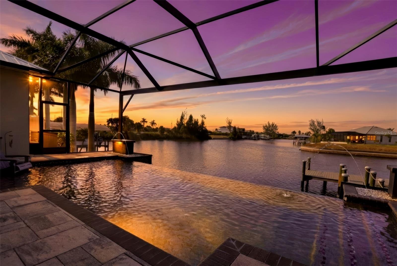 Your Dream Home Awaits: Custom Built Luxury on the Water with GULF ACCESS! NO BRIDGES or Obstructions! 

Step into a world where luxury meets tranquility. This custom-built home, nestled on a sprawling 180-foot wide canal, offers unparalleled access to the Gulf with NO BRIDGE standing between you and your dream adventures. Just a short, smooth ride by SAILBOAT or motorboat and you'll be cruising in the open air of the seas. The canal, with its average depth of 9' 6", welcomes even deeper-hull boats. 

As you walk through the impressive dual-door foyer, you’ll be immediately captivated by the panoramic views of the INFINITY-EDGE POOL that seamlessly blends with the serene canal beyond. The Great Room is designed to impress, featuring 10-foot high, zero edge, hurricane-rated impact doors that provide unobstructed views of both the pool and the expansive canal. Sliding doors from the dining room invite you to the outdoors, filling the home with natural light. The custom milled wood design on the 13' lofty ceiling enhances the majestic feel of the space, complementing the sleek LICO Hydro Fix flooring that spans the entire home—no carpeting here, just refined elegance at every turn. 

The gourmet kitchen is nothing short of a culinary masterpiece. Warm French Roast Textured Cabinetry by Strata, top-of-the-line appliances, and a stunning 10-foot island with Pompei Luxury Quartz counters are just the beginning. Whether you're an aspiring chef or simply love to entertain, this kitchen is an absolute showstopper. This spacious home features 5 bedrooms with 3 full bathrooms and a thoughtful split-bedroom floor plan to ensure privacy for all. 

The attention to detail is evident in every corner, even has R-19 Spray Foam Insulation in the attic to the galvanized steel roof with solar panels. Energy efficiency and comfort are paramount, as is the Whole House Reverse Osmosis System, providing pure, refreshing water from every faucet in the home. 

Outdoors, the custom pool is a true retreat. Sun-soaking ledges and a beautiful lighting system create a serene atmosphere perfect for relaxation. The pool's Zero Edge Infinity design gives the illusion of water flowing directly into the canal. With the best-in-class Super Screen pool cage, featuring a full picture window, you’ll enjoy unobstructed views while soaking in the Florida sunshine. The custom pool dock, complete with a Captains Walk,offers a perfect spot to fish or watch the boats go by. Plantation shutters and other custom window treatments add a touch of sophistication to the entire home. 

For those who appreciate the finer things in life, the garage is a true gem. With epoxy flake floors featuring filled cuts and baseboards, a mini-split air conditioner, and an upgraded Wayne Dalton 9100 insulated garage door, it's an ideal space for everything from vintage car storage to DIY projects. 

This home is more than just a house—it’s a lifestyle. Are you ready to LIVE THE DREAM?