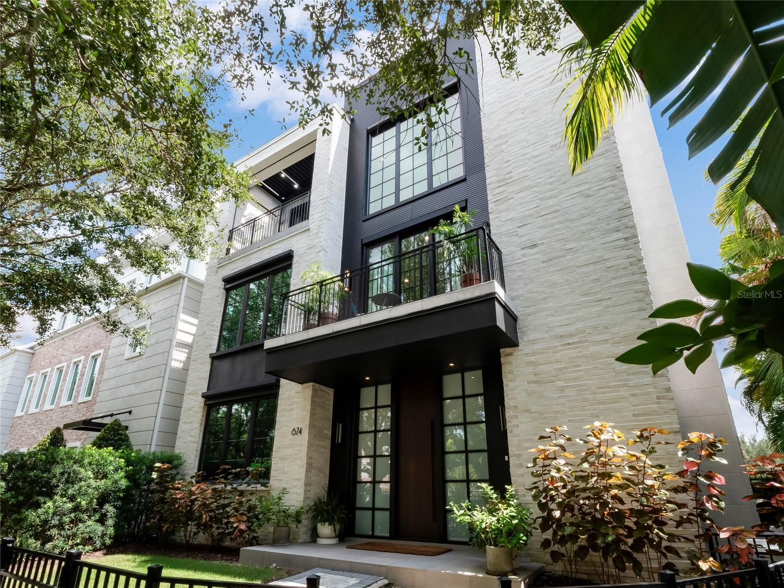 This stunning DETACHED LUXURY, URBAN, ELEVATOR home, meticulously crafted by the renowned Phil Kean Design Group, presents itself as an opulent haven in the heart of Downtown Winter Park, FL. With innovative modern architecture & state-of-the-art technology, this magnificent residence has been classified as a Net Zero/-16HRZ energy rating, producing more power than it uses, making it one of the most eco-friendly homes on the market. Designated as a showcase home for the National Association of Home Builders & International Builders Showcase, the interior spanning across three levels, boasts elegance coupled with unsurpassed luxury. The grand entrance on the FIRST level welcomes you with an exquisite gallery, adorned with conversational spaces, an en-suite bedroom, an office or bedroom, a mud room with doggie door, fenced dog run, & a spacious oversized 3 car garage equipped with an electric car charger and overhead storage system. Ascend to the SECOND level and discover the primary owner's suite, an absolute masterpiece, with a spa-like bath fitted with a steam shower, a lavish & posh walk-in closet with showcase lighted storage & a storage island.   A workout room/additional bedroom) with a full-sized sauna adds to the retreat-like atmosphere of this floor.  Here there is a large loft/flex space perfect for a lounge or office and a beautiful laundry room with double LG washer & dryer sets and a phenomenal dry-cleaning closet, the next must have appliance! The TOP level of this home is a showstopper. With an open-concept design and breathtaking green views from every angle, this luxurious and expansive area will be the perfect place to entertain guests or unwind after a long day. This level features a well-lit dining area, a stunning wet bar, a warm and cozy fireplace, 2 outdoor balconies ideal for basking in beautiful views and enjoying Florida’s outdoor living. The exquisite kitchen, hailed as the "Best Kitchen in Country 2020," will be a chef’s dream and is fitted with state-of-the-art Wolf & Signature appliances, including a 48-inch dual fuel range and 4 Wi-Fi-enabled smart ovens & a sous vide cooking system for perfectly cooked meals every time. The kitchen also features a built in Espresso Maker for a perfect coffee to compliment the beautiful surroundings. Lighted, Temperature-controlled wine towers built to impress any wine connoisseur and boast ample space for up to 600 bottles of your favorite vintage. The home is unique in every sense of the word. With its 14-foot ceilings, 12-foot external doors, symphony of natural light, and awe-inspiring views, the home is a haven of unparalleled sophistication. The floating walnut staircase with unique underlighting will surely captivate your attention & add a touch of class to the space. The elevator with leather walls and brass flooring provides easy access to all three floors and adds to the home's elegance. Additional features, such as a whole-home generator, state of the art home security system, Panasonic air filtration system, 2 tankless, gas water heaters, Control4 Home automation system, outdoor terraces, summer kitchen, and automated louvered porch roofing system, solar panels on roof, & remote-controlled balcony screens will deliver convenience and peace of mind to all.  Located in Hannibal Square's dining and shopping district & a short 3 block walk to Park Avenue for entertainment, dining, shopping, museums and galleries, and Central Park for picnics, strolls and Festivals.