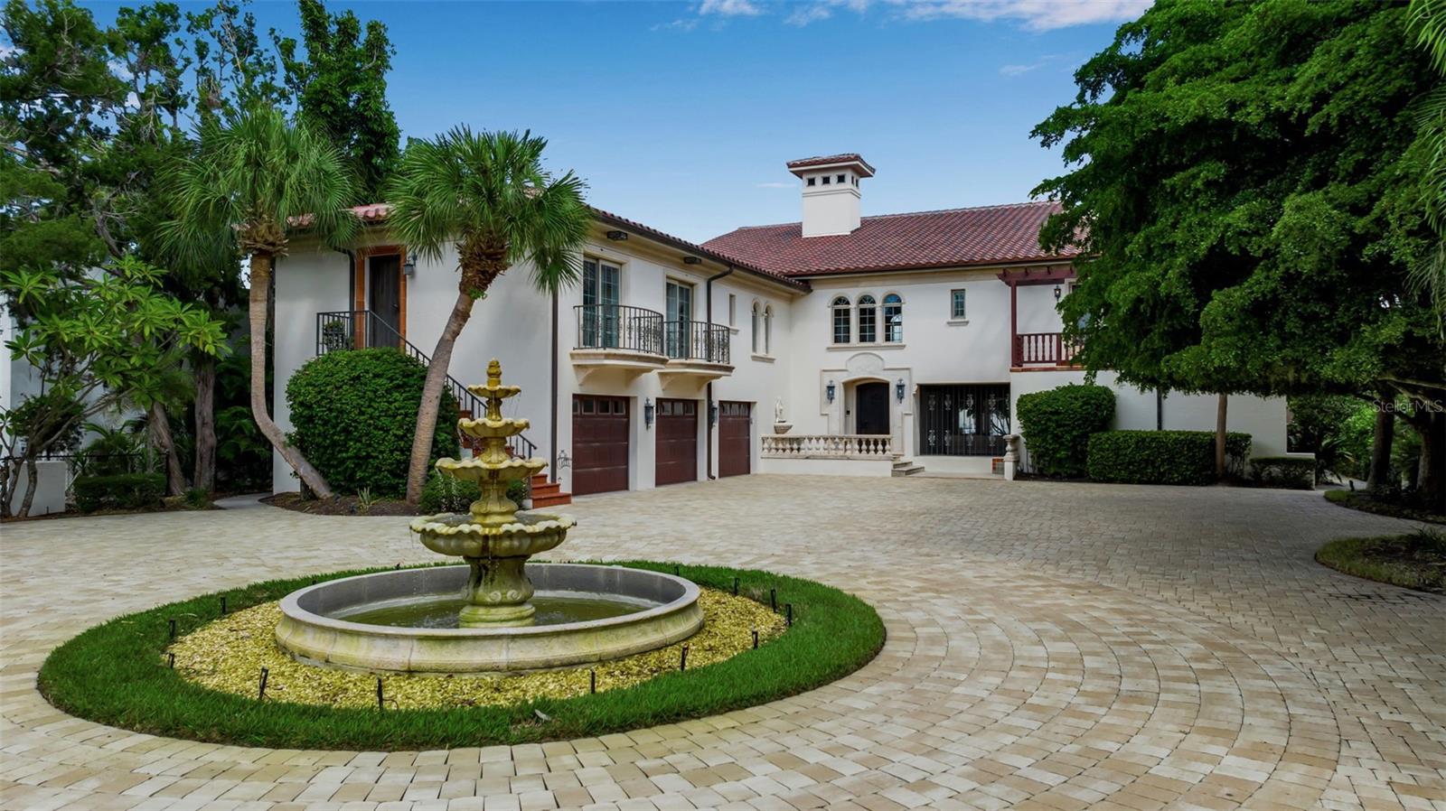 Welcome to Casa Della Fontana — The Fountain House. Nestled on the tranquil north end of Siesta Key, this gated waterfront estate is a blend of seaside serenity, architectural distinction, and lifestyle luxury. Perched on a deep, sailboat-accessible bayou that connects to the Intracoastal Waterway, the almost half acre lot provides generous room for outdoor living, boat docking, and privacy.

Built by Magnum Builders, this residence was recently transformed through a multi-year, high-end renovation to blend modern amenities with timeless character.  The home is engineered with concrete footings, steel pilings, and reinforced concrete/rebar, designed for storm resilience.  A Spanish barrel tile roof (2024), hurricane-rated garage doors and a whole-house generator round out the safety and durability features. 

This residence spans 6,827? square feet of air-conditioned living space offering 4 bedrooms, 4 full baths, and 1 half bath. At the heart of the home is the great room, soaring to 20-foot ceilings, commanding sweeping water views, and anchored by a two-story library wall.  A gallery and loft overlook the formal dining space, and elegant iron railings and hand-hewn wood trestles bring an artisanal, Old World feel.  A hidden wood-paneled staircase adds a dramatic, secretive touch. 

The gourmet kitchen is outfitted with Wolf, Sub-Zero, and Miele appliances, quartzite countertops, a coffered ceiling, a waterfront breakfast nook, and a walk-in pantry.  Hand-hewn beams extend throughout the kitchen and lanai, harmonizing the interior and exterior aesthetic. 

The primary suite is a sanctuary: two private balconies, dual bathrooms, a central walk-in shower with dual entry, and twin walk-in closets.  The guest wing, with three bedrooms and three baths, provides privacy and independent access to the driveway. 

Additional interior amenities include a media/game room, office/library, elevator, high ceilings, built-in features, central vacuum, and smart home automation. 

Designed for entertaining and coastal living, the property features a heated/in-ground gunite pool with spa, a sizable lanai with kitchen and multiple alfresco seating areas. For boating enthusiasts, the dock features three lifts and docking for large vessels.

Living here means effortless access to both island leisure and Sarasota urban life. You’re just minutes from Siesta Beach’s famed white sand, Siesta Key Village’s shops and restaurants, and the art, culture, dining, and amenities of downtown Sarasota.  The home’s deep-water location makes boat outings to the Gulf a delight.

Casa Della Fontana is more than a house — it’s a waterfront masterpiece built for those who demand beauty, durability, and lifestyle in equal measure. With its structural reinforcements, state-of-the-art systems, and sophisticated design, it offers both peace of mind and the romance of island water front living.