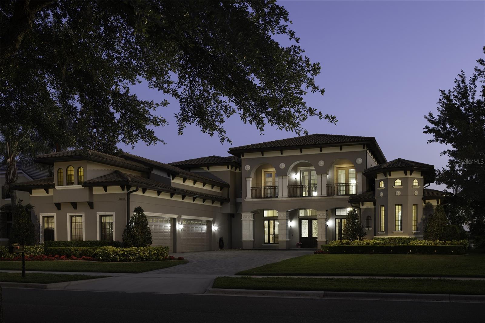Experience the pinnacle of luxury lakefront living in this breathtaking, custom-designed estate on the highly coveted shores of Lake Hancock—a premier destination known for championship water skiing, unforgettable sunsets, and nightly views of the Disney fireworks. This exquisitely crafted home offers expansive panoramic water views from nearly every room and showcases impeccable craftsmanship, timeless architectural details, and a thoughtfully designed layout perfect for both elegant entertaining and everyday comfort. Step inside to a grand, open-concept living area that flows seamlessly to a wraparound lakeside lanai, ideal for hosting guests or enjoying the peaceful ambiance of waterfront living. The gourmet kitchen is complemented by a formal dining room, a fully equipped butler’s pantry with wine cellar and prep sink, and a spacious laundry room with granite countertops and abundant utility space. Designed for entertaining on the main level, the upstairs offers a more relaxed retreat with a secondary living room/game room opening to a screened-in second-story balcony that provides stunning lake vistas. The first-floor primary suite is a serene sanctuary, featuring dual walk-in closets, separate granite vanities, and a spa-like primary bath with a step-up Jacuzzi tub. A second bedroom suite on the main floor is perfect for multigenerational living or guest accommodations. Car lovers and hobbyists will appreciate the five-bay, oversized four-car garage offering abundant space for vehicles, boats, golf carts, or a workshop. Above the garage, you'll find a dedicated home theater, offering a private retreat for immersive movie nights and entertainment. Two home offices provide plenty of space for remote work, creativity, or study. With its generous floor plan, high-end finishes, and unbeatable location, this impeccably maintained estate offers an extraordinary blend of elegance, comfort, and lifestyle in one of Central Florida’s most prestigious lakefront communities. Move-in ready and waiting for you to make it home.