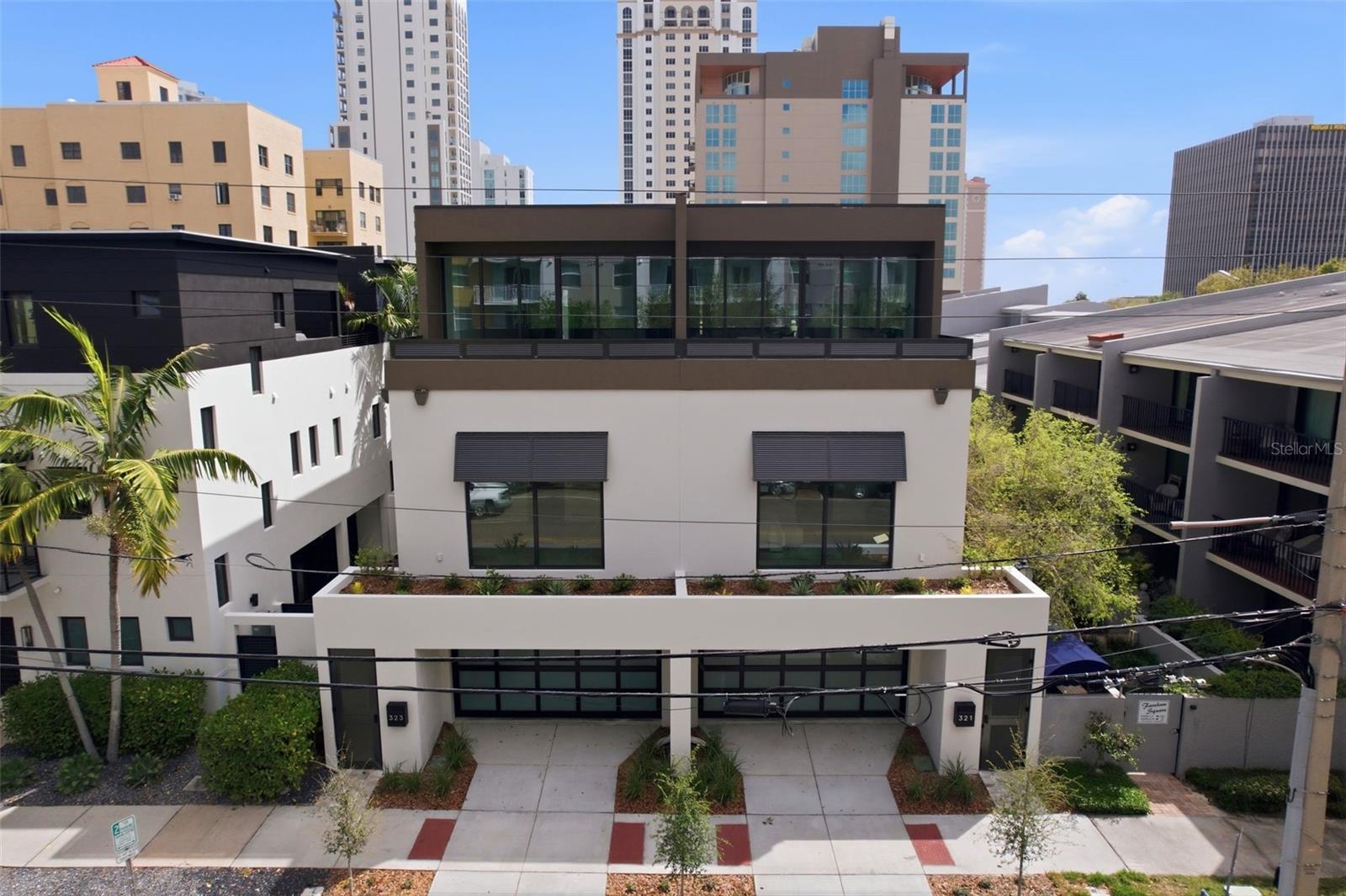 Welcome to 321 2nd St N in the heart of vibrant Downtown St. Petersburg—one of two truly remarkable, custom-designed townhomes by Next Design & Build. Offering 3 bedrooms plus a den, 4.5 bathrooms, a private elevator, and a 2-car garage, this three-story residence spans approximately 3,900 square feet of thoughtfully curated living space. Enter through your private front entrance to the first level, where a versatile flex space with a full bathroom offers the ideal setup for a home office, den, or can easily function as a fourth bedroom. This level also features a dedicated laundry room, access to a rear porch and backyard, and entry to the attached two-car garage. A custom elevator provides seamless access to all three floors. The second level is dedicated to the home’s sleeping quarters, including a spacious primary suite that serves as a true retreat, complete with a spa-inspired bathroom. Two additional generously sized bedrooms, each with their own en-suite bathrooms, offer comfort and privacy for family or guests. The third level is the showpiece of the home—an expansive open-concept living space designed for both everyday living and elevated entertaining. The chef’s kitchen features double islands, custom cabinetry by Stephen D. Fine Cabinetry, and a premium Sub-Zero and Wolf appliance package, including double ovens. A butler’s pantry enhances both form and function, while the living area opens seamlessly to a spacious balcony, perfect for enjoying fresh air and the energy of downtown living. A stylish half bath completes this level. Throughout the home, you’ll find high-quality finishes and thoughtful details, including hardwood flooring by Integrity Flooring, luxury tile and quartz surfaces, trimless doors, and impact-rated ES windows and doors, including the garage door. A striking wraparound staircase with glass railings and a custom elevator serve as both functional elements and architectural focal points. Comfort is ensured year-round with three LG 19 SEER A/C systems, providing efficient, zoned climate control. A rare opportunity to own a one-of-a-kind luxury townhome in one of St. Petersburg’s most sought-after locations, just moments from downtown dining, waterfront parks, and city amenities