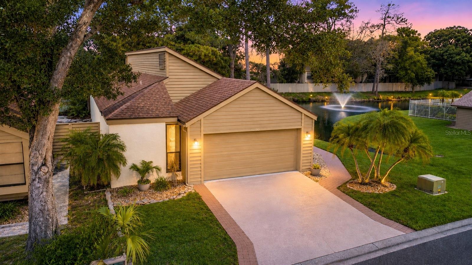 Nestled in the desirable Sweetwater Oaks community located in the heart of The University of South Florida and Moffitt Cancer Center, this 3-bedroom, 2-bath, 2-car garage condominium residence combines the convenience of low-maintenance living with the privacy and feel of a single-family home with no shared living walls. Spanning 1,647 sq ft of comfortable living space this rare residence offers a stunning pond view from both the rear and side of the home. Enjoy a peaceful setting where ducks and turtles gather around the picturesque fountain pond, creating a tranquil backdrop for everyday living. A tiled walkway from the double driveway meanders around to the side facing the front door passing the pond view on the side. Exterior siding displays Hardie Board and cedar planks. Major updates include a new roof (2021), windows (2023), and additional upper south-side siding replacement currently underway (June 2026). The HVAC system was installed in 2017, ducts replaced in 2021, and professionally serviced in 2026. Inside, wide-plank luxury vinyl flooring flows throughout much of the home, complementing the vaulted ceiling and recessed lighting in the spacious living room. The dining area flows seamlessly into the main living spaces, making entertaining easy and inviting. Sliding glass doors open to a fully enclosed, air-conditioned Florida room overlooking the water, providing flexible space for relaxing, entertaining, or enjoying the serene views year-round. Just outside through the double french doors, a patio offers another opportunity to take in the beautiful pond and fountain setting. A perfect setting to enjoy morning coffee or evening sunsets while watching the wildlife around the pond. The kitchen is designed for both style and functionality, featuring abundant cabinetry, stainless cabinet hardware, granite countertops, subway style tile backsplash, stainless steel appliances, and a stainless undermount sink positioned beneath a window with water views. A dramatic floor-to-ceiling window with stunning water views fills the space with natural light. A portable island on wheels provides additional workspace and sliding glass doors open to the Florida room. The spacious primary suite serves as a private retreat, featuring a walk-in closet, and an ensuite bath enhanced by a skylight that fills the space with natural light. The bath showcases a granite-topped double vanity with dual sinks and a tub/shower combination with a seamless glass enclosure. Sliding glass doors open to an adjoining flex room offering a perfect space for a nursery, home office, fitness room, study, sitting area, or private retreat. Generously sized secondary bedrooms offer ample closet space and flexibility for family, guests, or a home office. Bedroom two features tile flooring, a ceiling fan and sliding glass doors leading to the enclosed Florida room, while bedroom three offers tile flooring and a spacious closet. The secondary bathroom is appointed with a granite-topped vanity and a tub/shower combination. A dedicated laundry room offers cabinets, attic access and washer/dryer hookups. Conveniently situated with quick access to I-75, Fletcher Avenue, Fowler Avenue and Bruce B Downs, this home offers easy access to shopping, dining, medical facilities, parks and everyday conveniences. Schedule your private showing today and discover everything this Sweetwater Oaks gem has to offer!