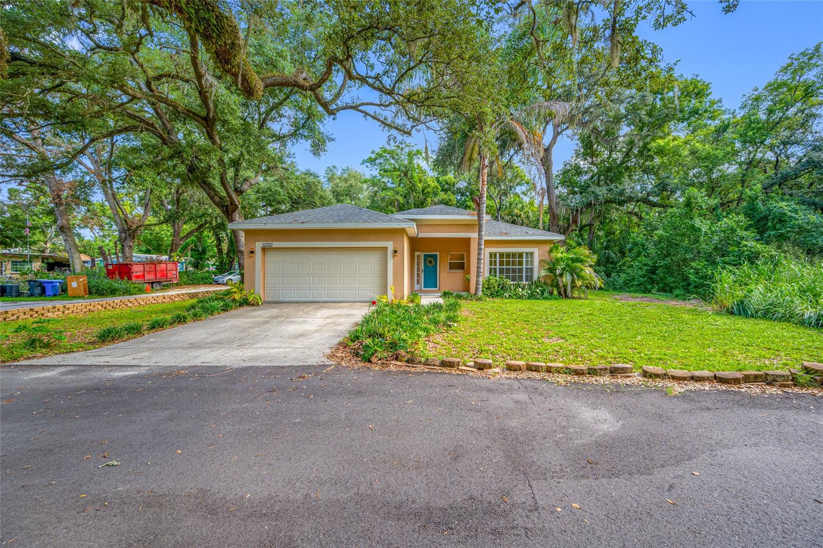 Virtually Staged. Privacy abounds in this one-owner 3-bedroom, 2-bath, 2-car garage home, built in 2006. Tucked away on a 3/4 acre lot near the end of a quiet, non-through street in North Tampa. Surrounded by woods on three sides, this property offers an exceptional sense of privacy with no backyard or front yard neighbors. Directly across the front street driveway belongs to this owner's homesite, and it cannot be built on, but it's reassuring to know that its preserving both your peaceful surroundings and natural views for years to come. You could also use it for extra parking or RV parking. NO HOA! Once inside this home, you will love the spacious open-concept floor plan which is filled with natural light and features high ceilings, creating an inviting atmosphere that's perfect for both everyday living and entertaining. The kitchen offers a convenient breakfast bar with seating for three and flows seamlessly into the living and dining areas. Great laundry room just off the kitchen, which also leads out to the garage. From the great room, french doors open to the backyard and covered patio, providing effortless indoor-outdoor living. The desirable split-bedroom floor plan offers added privacy, while multiple closets and built-in storage throughout the home provide exceptional functionality. The spacious primary suite serves as a relaxing retreat with dual vanities, a soaking garden tub, a separate walk in shower, and 2 spacious walk-in closets. Enjoy peace of mind with valuable recent updates, including a NEW ROOF (2025), NEW SEPTIC PUMP (2024), and DISHWASHER (2023). Conveniently located with quick access to I-275,  Downtown Tampa, shopping, dining, and more, this home offers the perfect blend of privacy, space, and accessibility at an affordable price! Not to mention great schools, including the much desired Gaither High School!  Opportunities like this are rare—a homesite surrounded by nature, enhanced by your own private land across the street, all while remaining close to everything Tampa has to offer. Don't miss your chance to make this unique property your own! No flooding during any of the hurricanes! Come and see what a great place this would be to call home! Room sizes are estimated, please verify if important to you.
