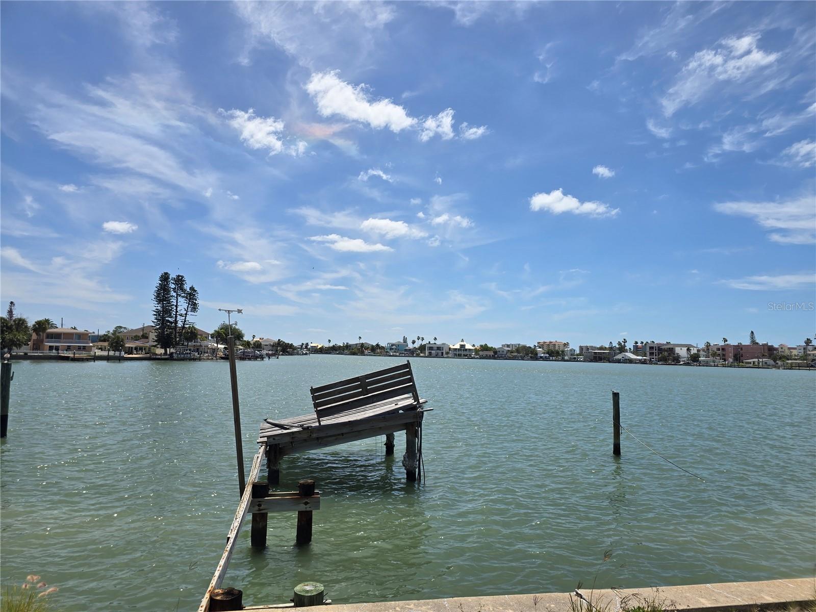 Exceptional waterfront redevelopment opportunity in the heart of Madeira Beach. This 50x100 open-water lot at 249 144th Ave offers direct Intracoastal access with only the Johns Pass bridge between you and the Gulf, making this an outstanding site for a custom coastal residence or luxury spec build. The existing storm-damaged structure is being sold strictly AS IS for land value, with the true value centered in the lot, water frontage, and incredible open-water views across a basin lined with newer construction and high-end waterfront homes. The existing dock sustained significant storm damage and will require replacement, creating the perfect opportunity to design a new dock and lift configuration tailored to today’s boating lifestyle. This is the type of Madeira Beach lot that becomes harder to replace each year—surrounded by strong redevelopment momentum, upscale neighboring homes, and one of the most walkable boating-and-beach lifestyles in Pinellas County. Just a short walk to the sugar sand beaches, John’s Pass Village, waterfront dining, and entertainment, this location offers the rare combination of boating access, beach proximity, and premium rebuild upside.  Whether you are building your forever waterfront home or positioning a high-end spec project in a market where coastal teardown lots continue to strengthen, this property offers exceptional long-term value in one of Tampa Bay’s most desirable beach communities.