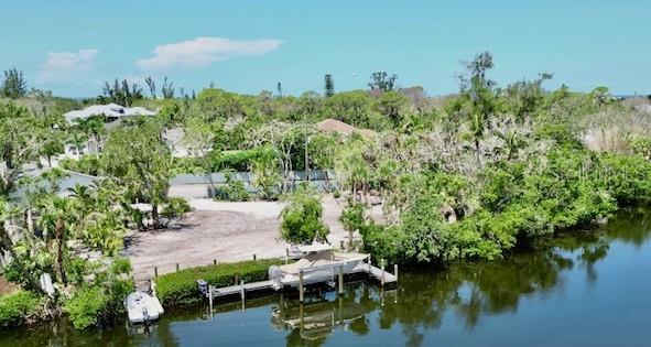 LIVE, BOAT, PARK while you build your waterfront dream home. ONLY waterfront lot on Siesta Key with Current 2/1 ADU and 3-car garage on property! Premiere boating/waterfront lot opportunity in Sanderling Neighborhood. A rare chance to own one of the most sought-after lots in Sanderling. This private, fenced, waterfront retreat is located directly across from the neighborhood’s gated entrance, nestled in a serene basin leading to the Intracoastal Waterway. Extensive upgrades allow the future owner to enjoy the property immediately or stay on-site while building a custom beach home. Current ADU on property is offered Turnkey Furnished! Direct Waterfront Access ~150 ft of frontage along a private canal connected to the Intracoastal. Shared with only 5 neighboring Sanderling homes for enhanced privacy and exclusivity. New Garage & Apartment (2024) Two-story, block construction featuring a 1,100 sq ft 2BR/1Bath apartment with full kitchen above an oversized 3-car garage—perfect for storing vehicles, kayaks, golf carts, and more. Expansive Lot ±0.6 acre (25,553 sq ft) fenced lot with over 240 ft of frontage. Adjacent to HOA-owned land for added space, privacy, and mature vegetation—lives "like" a 1+ acre compound. Dock & Boat Lift Brand-new dock with a 10,000 lb. lift, ready for Gulf Coast boating and fishing. A 28 ft Scout boat (optional) currently sits on the lift and can be offered under a separate bill of sale. Build-Ready & Custom Plans Available. Lot is fully cleared and prepped for a custom-designed coastal contemporary home (3,300 sq ft, 3BR + Den, 4.5 Bath, pool, lanai, and more). New Build House Plans available or you can work with local Sarasota architects to tailor your dream design. Living in Sanderling means more than simply owning a piece of paradise. The neighborhood offers a suite of exclusive amenities designed for relaxation, recreation, and connection. Residents enjoy exclusive access to the soon to be newly updated Sanderling Beach Club and existing tennis & pickleball Courts: Whether you are an avid player or simply enjoy a casual match with friends, well-maintained courts are available for your enjoyment. This property stands alone in its exceptional array of features and amenities.