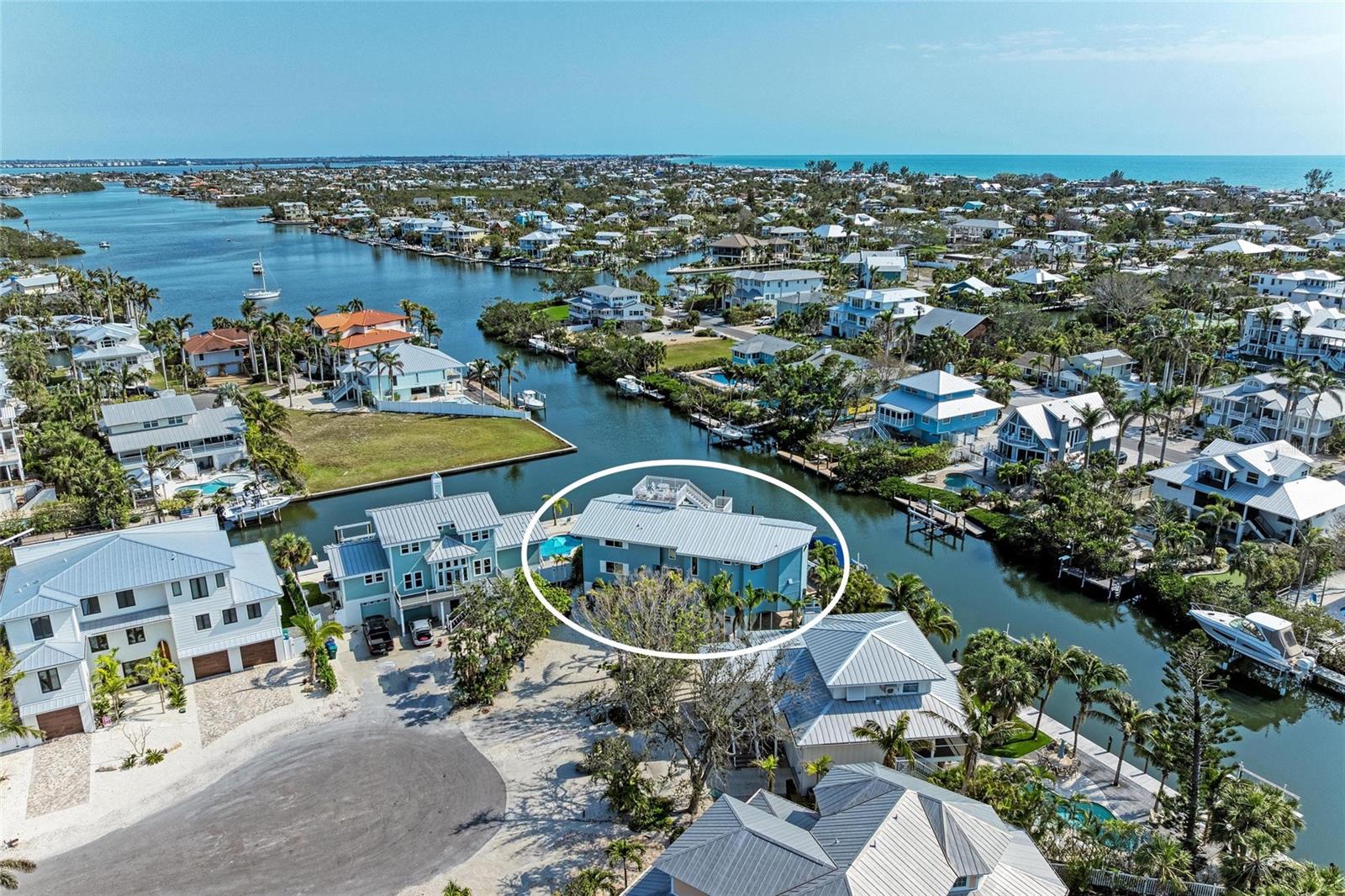 BRING THE BOAT! BRING THE FAMILY!  Fun and relaxation for all in this spacious 4 bedroom home with over 130 feet of frontage on a deep water canal.  There are no fixed bridges, so sailboats are welcome. Meticulously renovated in late 2017, this lovely home shows pride of ownership and is located on a peaceful cul-de-sac within close proximity to Anna Maria's best restaurants, shops and beaches. There are two levels of living area elevated over a two-car garage with bonus rooms and workshop. The open floor plan allows for a comfortable flow between the kitchen, dining area and family room. Of the four ensuite bedrooms, three offer water views, and two have deck access. The oversized pool, spa, putting green, roof-top deck and dock and hoist are complemented by balconies, covered patios and decks ... all perfectly situated for memorable gatherings of family and friends. The cooks will love the Wolf 6-burner gas range, Thermador refrigerator, fireclay farm sink, and beautiful granite countertops. Other important upgrades include a newer metal roof, a collection of impact rated doors and windows, two "endless hot" lp gas tankless water heaters and custom features including ship-lap siding in many rooms along with built-in shelving, beds and storage drawers. This property could make a wonderful primary or secondary residence, or continue to enjoy the income of its successful use as a weekly vacation rental home.  Property is offered turn-key furnished less personal exceptions.  Rental history is available upon request.