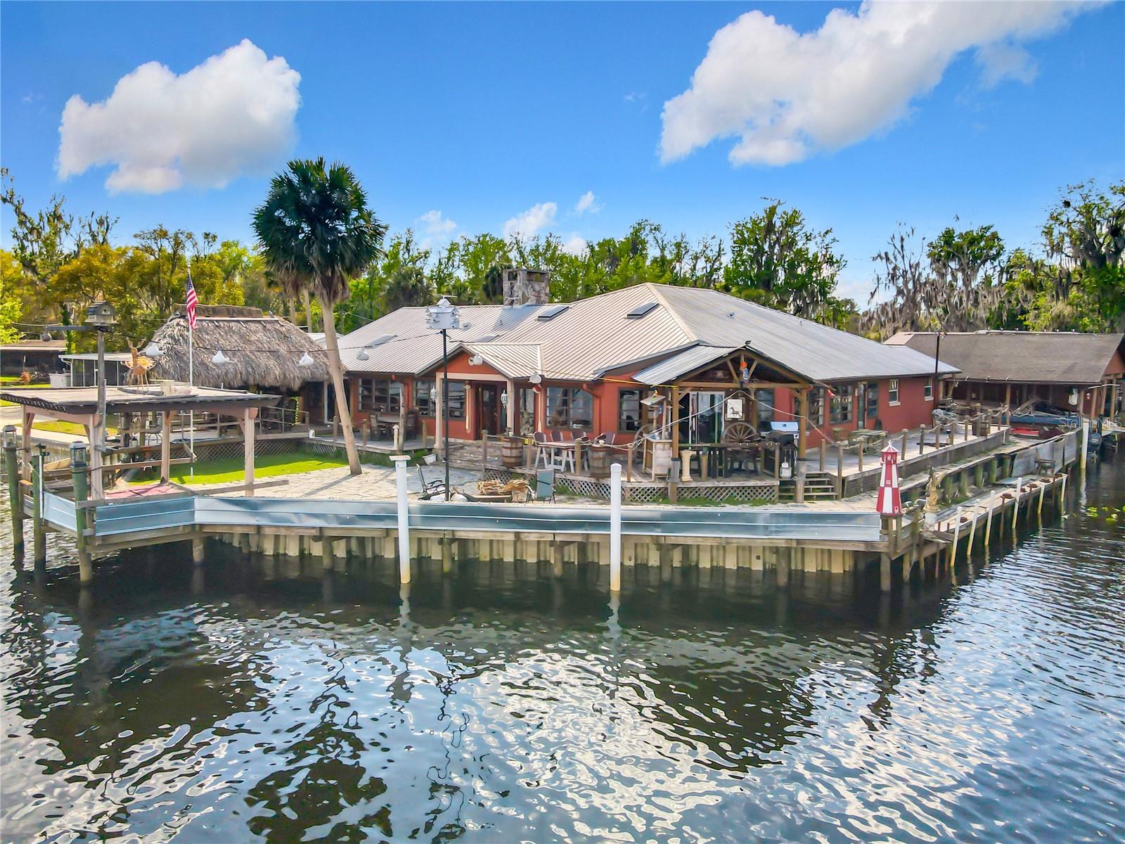 Experience true waterfront living in the heart of Astor with this private riverfront retreat offering nearly 300 feet of total water frontage and direct access to the iconic St. Johns River. Built for those who love the boating and fishing lifestyle, this unique property features three covered boat lifts capable of accommodating boats up to 30 feet, a boathouse, and plenty of room for multiple watercraft.

Outdoor entertaining is effortless with a large wraparound porch overlooking the water, a tiki-style gazebo, firepit area, and a dedicated fish cleaning station — creating the perfect setup for enjoying days and evenings on the river. The property also includes a covered RV port with a 50-amp hookup, plus abundant parking space for vehicles, boat trailers, RVs, and recreational toys.

Inside, the home offers a comfortable and inviting atmosphere highlighted by a built-in bar, ideal for gathering with family and friends after a day on the water.

Whether you're looking for a full-time residence, seasonal getaway, or weekend retreat, this exceptional waterfront property captures the best of relaxed Florida riverfront living.