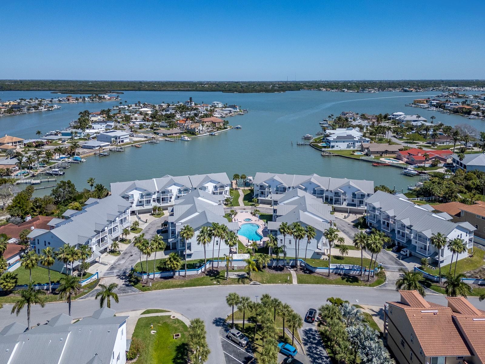 Carefree Beach Living can be YOURS at Tides Village! This spacious townhome is located in the gated community of The Villages of NRB - Yacht Club and has been extremely well-maintained. Over 2,500 square feet of living space on 3 levels includes lots of storage area as well as comfortably-sized rooms and an open plan on the main living level. The end unit location provides extra windows on the west-facing walls, inviting natural light. The first level includes an oversized 2-car garage with lots of storage space, a private patio, entry foyer and elevator. The second level is open, with hard wood flooring, and combines dining, living, kitchen and extra space for a library, media area or fitness area, and a generous covered balcony for al fresco dining or just relaxing. Spacious eat-in kitchen, complete with coffee nook and desk, and a cozy balcony to enjoy breakfast or tea. Recently remodeled kitchen upgrades include quartz countertops, glass tile backsplash, real wood soft-close cabinetry, microwave drawer, Bosch oven and induction cooktop, Bosch dishwasher; newer LG fridge.
The third level is a split bedroom plan consisting of the primary bedroom suite and two additional bedrooms, second full bath, laundry closet with sink, and two balconies. All bedrooms feature attractive transom lights and luxury vinyl plank flooring. The primary bedroom includes a large walk-in closet/dressing room, a spacious bath with dual sinks (brand new glass shower enclosure), and a private balcony with a partial water view! The two additional bedrooms have ample storage space as well and share a covered balcony overlooking the community. 
Other items of note include a Reme-Halo air purification system, water softener and water filtration system. New water heater 2025. Storm rated windows and doors throughout with the exception of primary bedroom sliders, which have roll down storm shutters.
This gated community consists of 28 townhomes located in the heart of North Redington Beach, with a heated swimming pool and spa, beautifully maintained common areas and a waterfront dock. Yacht Club is only steps away from local restaurants, town tennis court, and just across the street from the Gulf beaches. Priced to sell! Move-in ready! Home Warranty included!