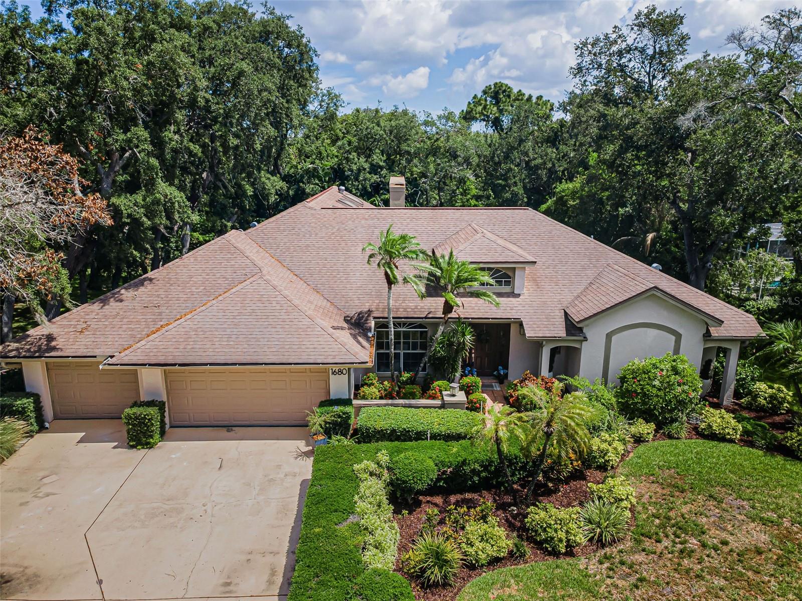 Your tropical oasis on one of the most prestigious city streets and rarely available in beautiful Dunedin awaits!!! Stunning and unparalleled curb appeal with thousands in tropical landscaping investment is just the beginning! Welcome to 1680 Sparkling Court, a four bedroom three bath, three car garage, pool home featuring the ever popular three-way split plan allowing for a great in-laws suite or home office set up! Privacy prevails at this CONSERVATION backdrop!!! Step into a grand foyer, towering ceilings off the elegant living room and dining room with gorgeous ceramic tile flooring and expansive views of the sunken pool. The chef‘s dream kitchen comes with endless cabinetry, a desk area, white appliances, granite countertops and backsplash, a massive island ideal for entertaining your guests and family gatherings and it overlooks an extremely spacious family room and breakfast nook area with a wall of custom glass insert doors showcasing the outdoors and adding tons of filtered lighting to the interior. The family room has a cozy, wood-burning fireplace, recessed and track lighting, built-in bookcases, a plant shelf, newer wide plank porcelain tile floorings and three skylights! All bedrooms have 10 foot ceilings, ample closet space as well. The owners sprawling suite includes wide views of the luscious exterior, a massive walk-in, a built-In and a master bath retreat that has it all to include two vanities, a garden tub, a separate shower stall, and a private commode area! Enjoy multi-zone, air-conditioning, two water heaters that are 1-2 years old, a spacious laundry room with a 2-year old washing Machine, a huge walk-in pantry, wider baseboards, and much more! The sunken pool has a brand new multi-color pool light, and an upper and a lower deck featuring two lounging areas, and above ground jacuzzi with a new Jacuzzi cover and pump for the ultimate relaxing and it truly feels like you are in your own oasis with all the foliage and exotic flowering and palm trees! Centrally located within minutes to eclectic downtown Dunedin with all its cafés and shops, Honeymoon Island, the Pinellas Trail, the beach, shopping, dining, the arts and TPA!