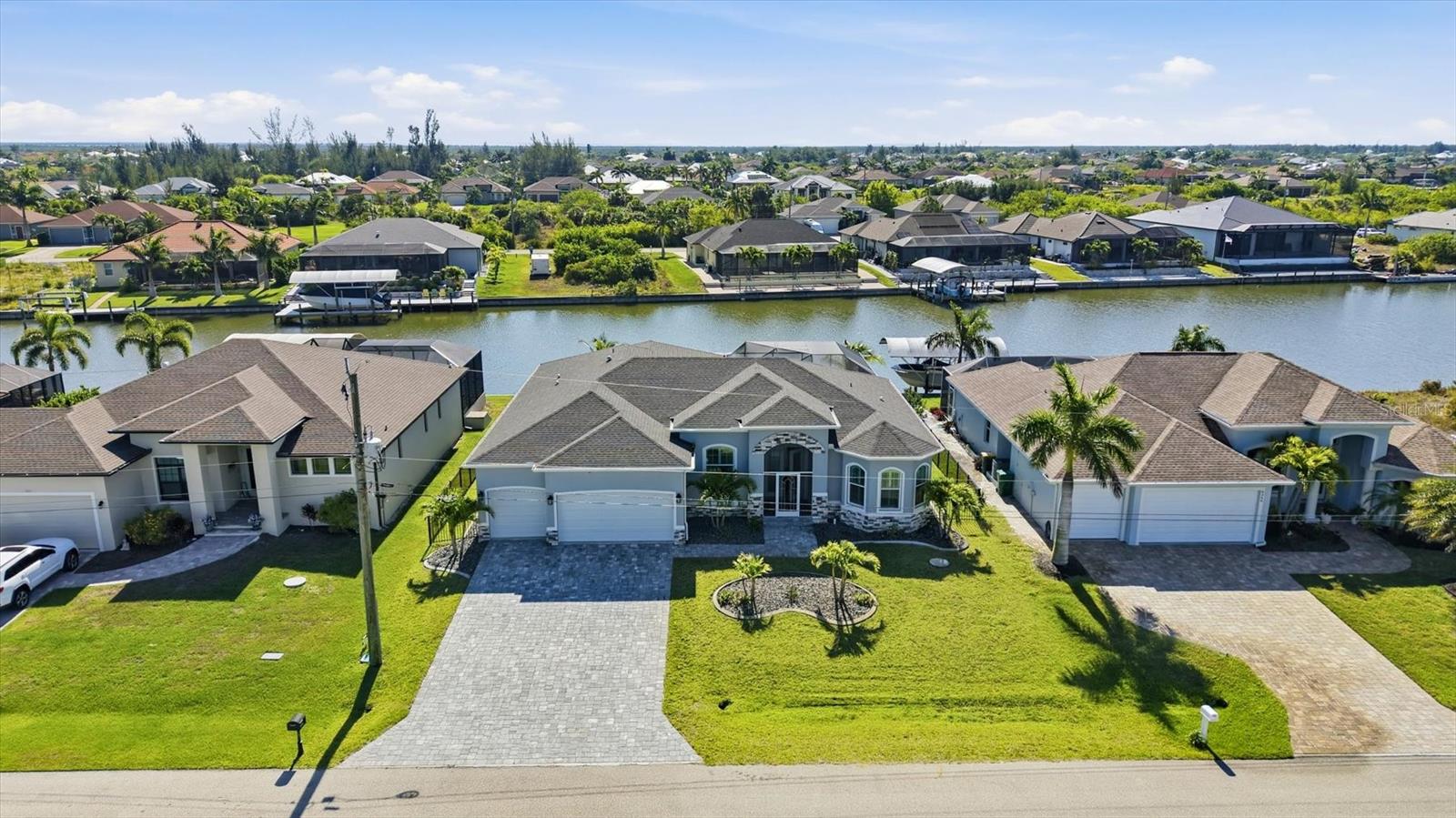 Welcome to your dream waterfront oasis in the highly desirable community of South Gulf Cove, where luxurious living meets serene natural beauty!  Come view this spectacular 2023 home built by Turn Key Custom Homes.  From the moment you arrive and step through the stunning French doors you’ll be greeted by a bright and airy great room featuring soaring tray ceilings, crown molding, and striking 5-inch baseboards.  
The heart of the home is the chef's kitchen featuring an oversized granite island, custom soft close wood cabinetry, beautiful backsplash, under cabinet lighting and power strips,  SS appliances, modern pendant lighting and a spacious walk-in pantry perfect for all your storage needs, all flowing effortlessly into the vibrant dining area with sliders to the lanai.
 Retreat to the luxurious primary bedroom which offers a serene haven with a lavish ensuite bath featuring a tiled Roman shower with dual shower heads, including a rain shower head, plus dual vanities and a makeup vanity, all adorned with beautiful granite countertops. The primary also features sliders that open to lanai offering a view of the canal. 
 For added convenience, a large laundry room is located just off the primary suite, making daily tasks a breeze. 
A versatile bonus flex room and/or den with a charming half-moon window and double doors offer perfect spaces for an office or a cozy guest retreat, enhancing the home's functionality. 
The guest bedrooms are strategically located on the opposite side of the home for privacy; one features a large walk-in closet complete with custom shelving and an ensuite bath with a tiled walk-in shower. 
 The expansive 10 ft zero-degree tinted sliders equipped with custom remote controlled shades provide seamless access to the paver lanai.  
Step outside to your tropical oasis where the heated, saltwater pool has been strategically placed in the corner for maximum sun exposure overlooks a tranquil canal setting.  The expansive lanai features plenty of covered seating, a separate dining/grilling area and even an outdoor shower. In addition the back yard is completely fenced with a decorative black aluminum fence for the added security for your pup!   Additional highlights of the stunning home include porcelain tile throughout, impact windows, sliders and garage doors, security system, sprinkler system, custom plantation shutters and custom shades on sliders and screened in front entryway.  There is also has a whole house generator the seller is willing to negotate with the sale.   Don’t miss this incredible opportunity to experience waterfront living at its finest in South Gulf Cove!