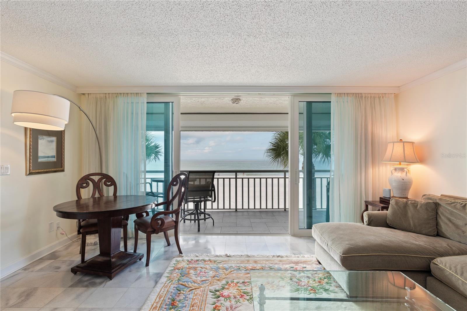 Carport Space #9 SOUTHWEST CORNER UNIT- Step into your fully furnished coastal sanctuary and experience the ultimate Gulf living! This stunning corner unit on the second floor offers breathtaking Gulf views from nearly every angle and every one of the three bedrooms. This residence showcases architecturally kitchen, bathrooms and built in storage in living room.   Floor-to-ceiling windows in the master bedroom offer picturesque beach views and exceptional natural lighting.  The open and spacious floor plan sets the stage for entertaining guests or simply unwinding in tranquility amidst the beautiful surroundings. Indulge in nightly sunsets over the Gulf from the comfort of your own slice of paradise. Belleair Beach offers Serenity & Privacy away from any hotels or large complexes - it is a small local community where you can experience the true Florida paradise. Imagine crafting delightful meals in the brand new kitchen featuring stainless steel appliances, newly upgraded wood cabinetry, and luxurious granite countertops with marble floors in the entire unit. Crown Molding throughout, with custom finishes, this condo exudes light and comfort. Meticulously cared for by its owner. Fully FURNISHED except for a few personal items.  Sereno Del Sol is an intimate & secured-access condominium community (only 40 units) that is built with the style of Mediterranean  architecture in mind, offering timeless elegance and charm. Adorned with graceful red-tiled roofs over the beautiful walkways on the second floor, a charming courtyard and terra-cotta accents, this community transports residents to a world of Mediterranean-inspired beachfront living and Gulf views.  Sereno Del Sol Condo allows 30-day rentals with no minimum ownership period before renting.  Included is a private Covered Parking space #9 with ample guest parking. Very close to the Shoppes of Sand Key, the renowned Columbia Restaurant as well as the Watercolor Grille, the Belleair Beach Marina you can lease a space for your vessel and various waterfront dining and shopping options, this locale epitomizes coastal living at its best.