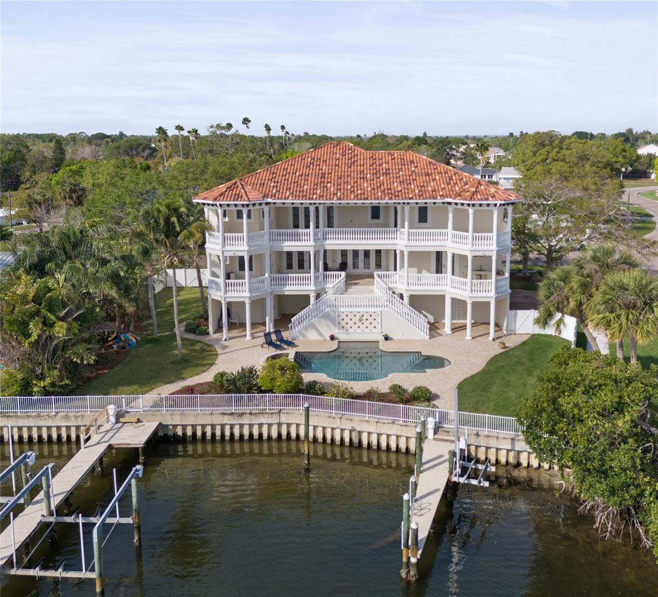 Your own private mini marina! This magnificent estate is situated on a true double lot with over 110' of deep sailboat waterfront, no fixed bridges to the Gulf, and panoramic views of Tampa Bay and Weedon Island Preserve. This waterfront oasis boasts dual docks with a 12,000 lb lift, 10,000 lb lift, PWC lift, and pilings to moor your yacht. The ultimate in luxury, this 4 bedroom, 6 bathroom Mediterranean home contains over 5,900 sqft of exquisite finishes, plus an additional 1,000 sqft bonus room (not included in the living space square footage) with ductless AC/heat and storage space. This home features imported Italian travertine floors that shine like glass, newly refinished walnut hardwood flooring, commercial-grade structural construction (steel beam supports and cement block from the foundation to the top of the 3rd floor), custom cabinetry, one indoor and two outdoor fireplaces on each of the two 1,100 sq ft balconies overlooking open views of Tampa Bay and Weedon Island, an outdoor kitchen, an elevator to all 3 levels, and a custom oversized garage perfect for parking up to 7 vehicles. The grand floor plan offers formal dining and living rooms as well as an eat-in gourmet kitchen, office, library, luxury bar room, and breakfast nook.Watch the dolphin and manatee play from one of your docks or balconies. This priceless Bayou Grande location is less than 15 minutes to downtown St. Petersburg and 30 minutes to downtown Tampa and Tampa International Airport. First rate private schools just minutes away (Shorecrest, Canterbury, LCC) and the brand new Mangrove Bay Middle School. Over-the-top quality and lot size make this custom home a masterpiece that could not be duplicated at today's prices. The entire exterior and interior of the home have been freshly repainted. Brand new polyurea (stronger than epoxy!) floors have been installed in the 3000 sqft garage and have a transferable warranty to the new owner. All interior floors are either new or professionally refinished, along with many more updates! AC has six separate zones and all AC units are relatively new. Listing agent is the owner.