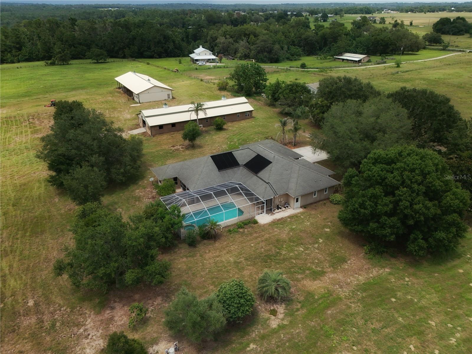 If you've been looking for acreage, multi-purpose barns, and a large home without being an hour from everything, you may have just found your forever home. Situated on just under 10 acres in southeastern Hernando County, this agriculturally zoned property offers the flexibility to accommodate horses, farming equipment, RVs, recreational vehicles, or simply the space to spread out and enjoy country living.

The home features 5 bedrooms, 3.5 bathrooms, 3,596 square feet of living area, and 5,039 total square feet under roof. A screened pool provides a great place to cool off after a day outdoors, while the home's size offers plenty of room for family, guests, or multi-generational living that centers, just as you would expect in a farm-house, around a massive kitchen with wood cabinets and lots of counter and cabinet space!

The centerpiece of the farm is a 4,212-square-foot stable with a wide center aisle, 8 to 12 stalls depending on your preferred layout, a tack room with double sinks, storage room, and 15-foot-tall roll-up doors. A farm office includes a private 1-bedroom, 1-bath living area that could serve a variety of uses. The center aisle is wide enough to accommodate RV or motorhome storage, making the building useful well beyond traditional equestrian purposes.

A second barn provides 4,535 square feet of additional space for hay, trailers, farm equipment, and implements. The structure includes a 41' x 23' enclosed workshop along with extensive covered storage designed to handle the demands of an active farm or rural lifestyle.

One of the biggest advantages of this property is its location. While surrounded by agricultural land and larger homesites, you're only about 10 miles from downtown Brooksville, approximately 6.5 miles from Brooksville-Tampa Bay Regional Airport, and about 38 miles from Tampa International Airport. Shopping, dining, medical facilities, and everyday necessities are all within easy reach.  For your convenience, the main house is also equipped with a generator and a water softener.  There are also some producing fruit Mulberry and Loquat trees on the property as well as Olive and Citrus that are not currently producing.


Whether you're looking for an equestrian property, a small farming operation, space for hobbies and equipment, or simply room to breathe, opportunities like this are becoming increasingly difficult to find in Hernando County.  Schedule your tour today before this opportunity is gone forever!




All information is intended to be accurate, however it is the responsibility of the buyer and buyer’s agent to verify all information prior to buying.