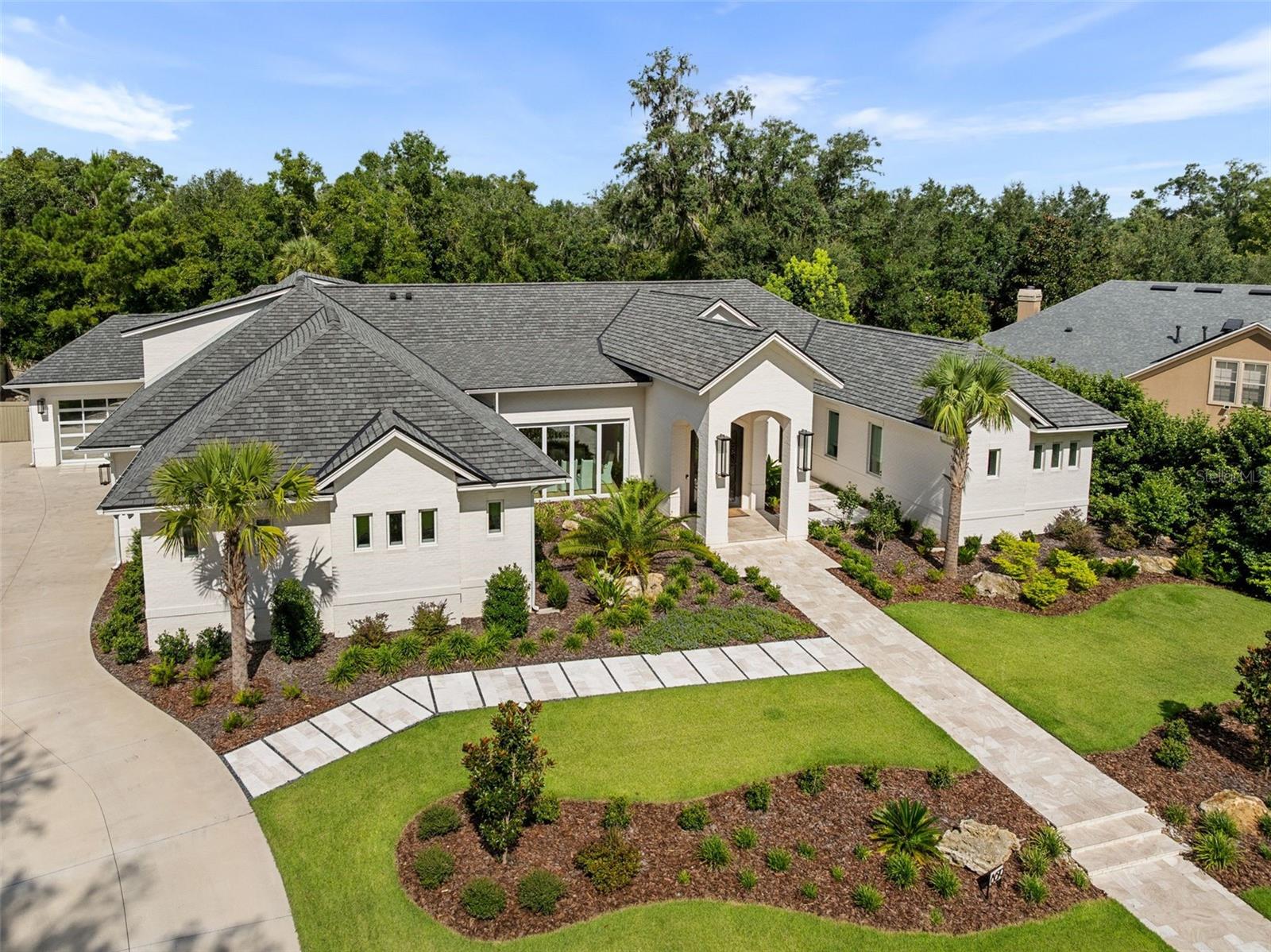 Experience the pinnacle of luxury living in this stunning, custom-built masterpiece in the highly sought-after Branton Court of Haile Plantation. With an impressive 6,937 sq ft of heated/cooled living space and an additional 572 sq ft of climate-controlled unfinished space, this exceptional residence blends timeless design, modern innovation, and superior craftsmanship. Constructed with energy efficiency and longevity in mind, the home showcases ICF construction, classic brick exterior, and an extended-life roof, delivering both durability and refined curb appeal. Step through grand, custom-forged iron doors into an expansive open-concept layout, bathed in natural light from dramatic, oversized windows that frame views of the lush surroundings. This architectural gem offers 6 generously sized bedrooms, 4 luxurious en-suite full bathrooms, and 2 half baths, all thoughtfully designed with both comfort and elegance in mind. The home’s interior is enhanced by rich, wide-plank wood floors that flow gracefully throughout the main living areas, adding warmth, sophistication, and timeless elegance. This home also includes a rare and fully handicap-accessible private casita with its own spacious bedroom and spa-like en-suite bathroom—ideal for guests, in-laws, or live-in caretakers. The heart of the home is a gourmet chef’s kitchen, equipped with top-of-the-line Wolf and Sub-Zero appliances including an induction cooktop, double ovens, steam oven, warming drawer. Custom Busby cabinetry adds richness and functionality, while the stylish wet bar features a second dishwasher, ice maker, and wine refrigerator. For the ultimate entertaining experience, the residence is equipped with a premium built-in surround sound system, delivering high-fidelity audio throughout key living spaces. Tucked behind the cabinetry, discover a spacious walk-in hidden pantry, offering abundant storage, discreet organization, and a touch of luxury that blends seamlessly with the kitchen’s clean, elevated design. Unwind in the versatile bonus room, ideal for a media lounge, home gym, or playroom. Advanced home technology includes the Moen Flo Smart Water Monitor and Shutoff System, offering 24/7 leak detection and remote water control for ultimate peace of mind. Enjoy a quiet evening under the covered patio with a fully equipped summer kitchen. This expansive outdoor cooking area features a professional-grade grill, flat-top griddle, and generous counter space. Brand-new custom pool completed in May 2026. Every inch of this estate has been meticulously curated with premium finishes, designer details, and custom features that set it apart. This home offers an unparalleled lifestyle of comfort, sophistication, and lasting value. Don't miss the opportunity to own one of Haile Plantation’s most distinctive and desirable luxury homes.