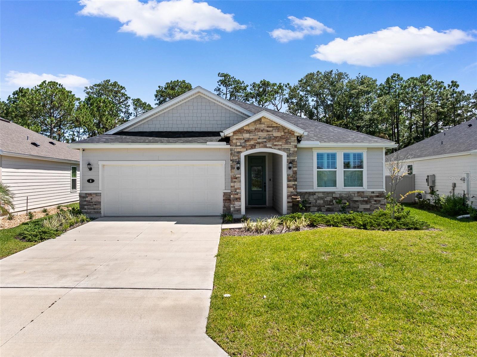 Welcome to your coastal oasis at 6 Signet Circle, nestled in the highly desirable community of Beach Park Village, Flagler Beach. Situated on a prime lot that backs up to a lush, private nature preserve, this home offers a serene, peaceful retreat just moments away from the pristine sands of Flagler Beach, local dining, and coastal amenities. This stunning, modern single-family residence perfectly blends contemporary luxury with ultimate functionality, starting with great curb appeal, a stone-accented entryway, a paved driveway, and a convenient exterior generator plug-in for peace of mind. Step inside to a bright, wide-open floor plan characterized by soaring ceilings, elegant recessed lighting, and beautiful, durable wood-look flooring that flows seamlessly throughout. The layout features a dedicated home office that has been thoughtfully double-insulated for soundproofing, providing the ultimate quiet workspace. At the heart of the home is a chef-inspired gourmet kitchen boasting an expansive central island with breakfast bar seating, crisp white shaker cabinetry, premium stone countertops, an elegant tile backsplash, a built-in double wall oven, and a professional range hood. Storage is exceptionally abundant with two separate pantries, both completely outfitted with custom built-in shelving. The spacious living and dining areas open effortlessly to a fully screened-in lanai, creating the perfect setup for indoor-outdoor entertaining. Retreat to the private primary suite, which includes a large walk-in closet featuring high-end custom built-in shelving and a spa-like en suite bathroom with a seamless glass walk-in shower. Throughout the entire home, premium plantation shutters offer the perfect balance of natural light, style, and privacy. Schedule your private showing today!