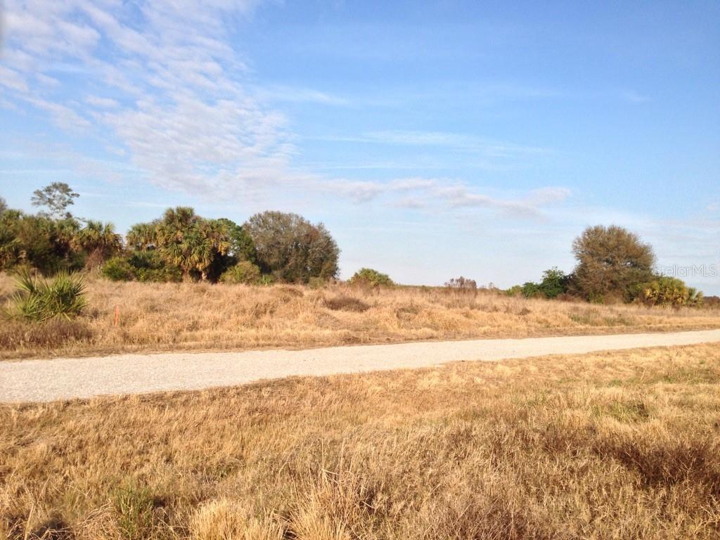 The rural landscapes of Southwest Florida possess a distinct character defined by history, resilience, and natural beauty. Nestled within eastern Charlotte County lies "High Prairie Oaks," a ten-acre parcel exemplifying the timeless appeal of the Florida prairie. Once a thriving orange grove, the land has reverted to its native state, transforming into a pristine pine flatwoods ecosystem dominated by sprawling oaks and majestic cabbage palms. Amid this wilderness, a few hardy citrus rootstocks—likely Cleo-Mandarin, orange, or lemon stock—have evolved into small trees, standing as living monuments to the land's agricultural past. This intersection of human history and ecological reclamation offers a profound sensory connection to the natural world. [1]
The regional lineage lends storied depth to the property. These expansive eastern prairies were once traversed by Spanish Conquistadors, inhabited by the Calusa Indians of Ponce de León fame, and later romanticized by Western artist Frederic Remington. In local folklore, they are remembered as the stomping grounds of legendary cattleman Bones Mizell. More recently, the parcel belonged to a 3,640-acre agricultural development engineered decades ago by the Freeman Brothers of Miami, later sold to American Agronomics and managed for international investors. While commercial production has ceased, the legacy of this enterprise remains visible in the infrastructure. Channels border three sides of the land, providing seasonal irrigation and drainage managed by the East Charlotte Drainage District. The main northern channel directs water westward via Myrtle Slough to Shell Creek, the Peace River, and onward to Charlotte Harbor.
Beyond its historical and hydrological significance, High Prairie Oaks serves as a sanctuary from modern urban life. Free from city light and noise pollution, the property is characterized by expansive quietude, underscored by the vast distance to neighbors. The landscape presents a dramatic visual display where vivid sunrises and sweeping sunsets yield to unobstructed views of millions of stars. This pristine canvas rivals the natural vistas that once inspired the great artists of the American frontier, offering an invaluable retreat for those seeking absolute privacy.
From a regulatory perspective, the parcel is safeguarded by Charlotte County’s Agricultural (AG) zoning. This classification preserves rural integrity by protecting agricultural operations and restricting residential development to a low density of one single-family home per parcel. It accommodates consistent uses like conservation, recreation, and light agriculture, ensuring the surrounding peace remains uncompromised by suburban sprawl. Building a homestead requires a private well and septic system, with electrical infrastructure positioned roughly 1,000 feet to the east. For individuals who desire a quiet, rural lifestyle, High Prairie Oaks stands as an exceptional opportunity to build a personal legacy on the historic Florida prairie.