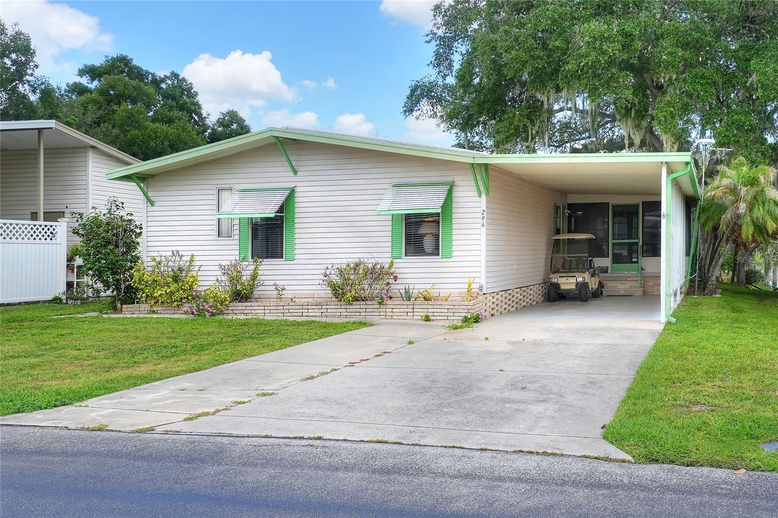 Embrace the ultimate waterfront lifestyle in this furnished and move-in-ready 2-bedroom, 2-bathroom manufactured home located in Bartow’s highly desirable 55+ Floral Lakes community. Offering the incredible perk of land ownership with no lot rent and low monthly HOA fees, this home is designed for easy, comfortable living. The kitchen is fully equipped with a refrigerator, range, range hood, dishwasher, a closet pantry, and a convenient breakfast bar for casual dining. Just adjacent, a cozy dinette area features a charming built-in china hutch. The layout flows effortlessly into the living room, where double French doors open into a large, enclosed rear patio with screen and vinyl windows. This seamless transition creates a wonderful indoor-outdoor living space where you can relax and enjoy beautiful lake views in year-round comfort.
Both bedrooms are finished with durable laminate flooring and feature spacious walk-in closets. The primary suite serves as a peaceful retreat, complete with an en-suite bathroom boasting a double vanity, a handy linen closet, and a shower enclosure with a sliding glass door. The second bedroom has quick access to the guest bathroom, which features a single vanity and a classic tub/shower combo. Adding to the home's utility is an indoor laundry room equipped with an included washer and dryer, alongside a built-in desk and extra cabinetry for storage. Outside, the property features a single carport and a spacious storage room for your tools and gear.
The true highlight of this property lies just out back, where a gentle grass slope leads right to your private wooden boat dock, allowing you to fish or launch a boat directly from your own backyard. Perfectly situated in Central Florida between Tampa and Orlando, this golf-cart-friendly neighborhood places you just minutes from the Bartow Civic Center, Bartow Public Library, and Mary Holland Park. As a resident of Floral Lakes, you will enjoy a vibrant community spirit and access to a stocked pond, community boat ramp, and a clubhouse packed with premium amenities—including a large heated swimming pool, putting green, shuffleboard, and a busy calendar of social clubs, dances, and potlucks. Please note that association approval is required for purchase. Don't miss this rare waterfront opportunity—call your Realtor today to schedule your private showing!